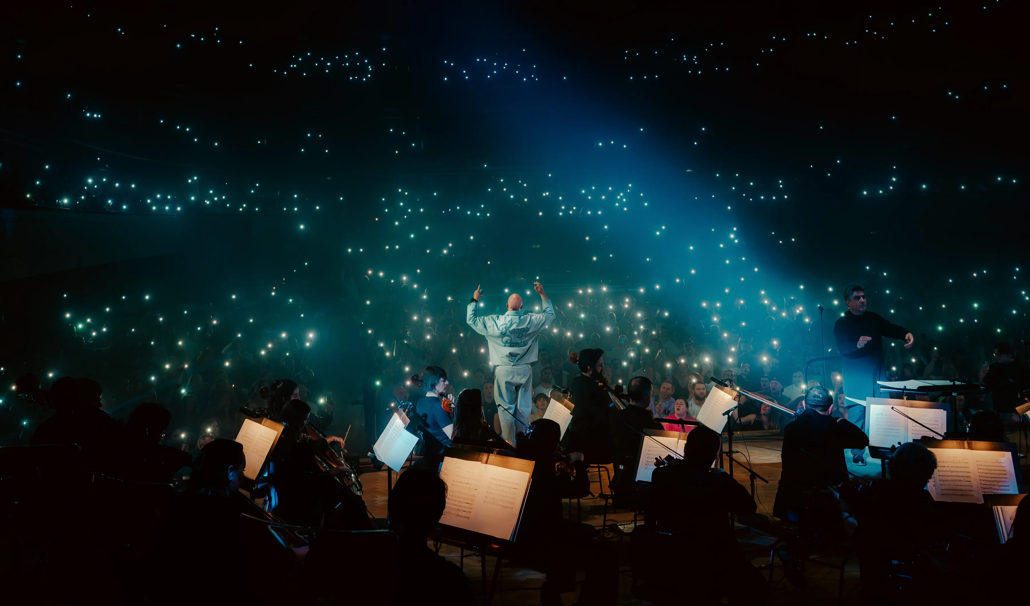 La salle éclairée par les lumières des téléphones pendant le concert de Scylla