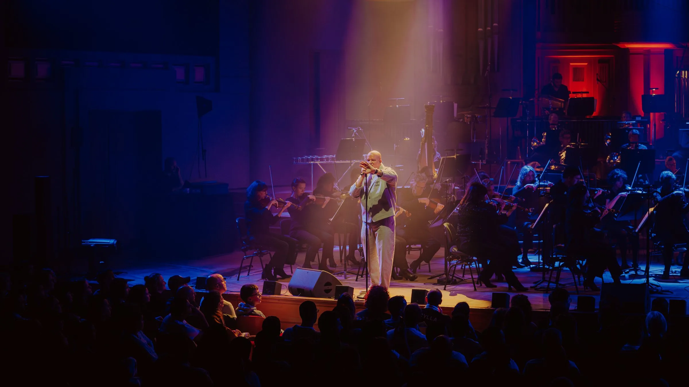 Scylla chante avec l’orchestre sous des lumières violettes