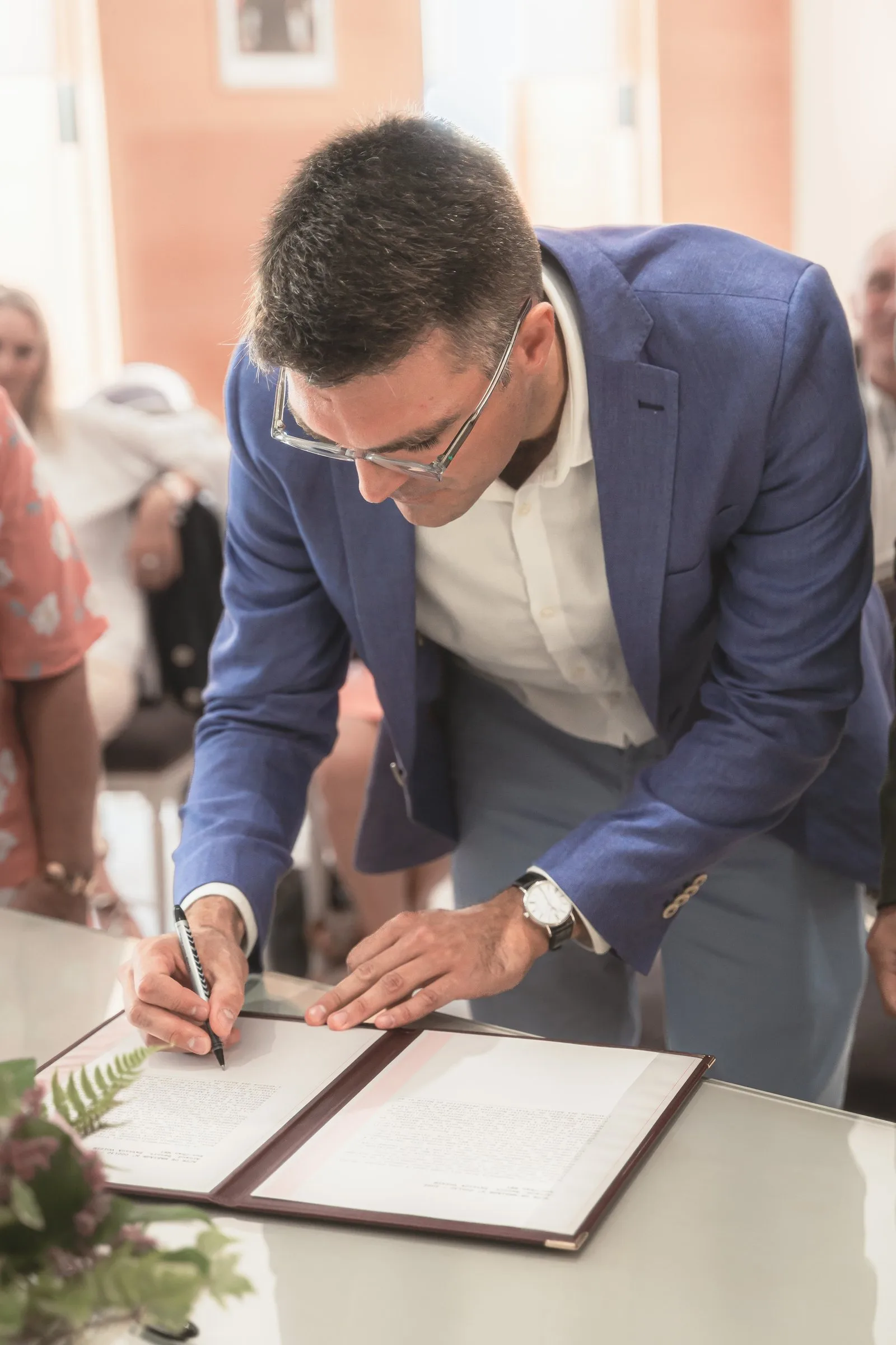 Un des mariés signe le registre