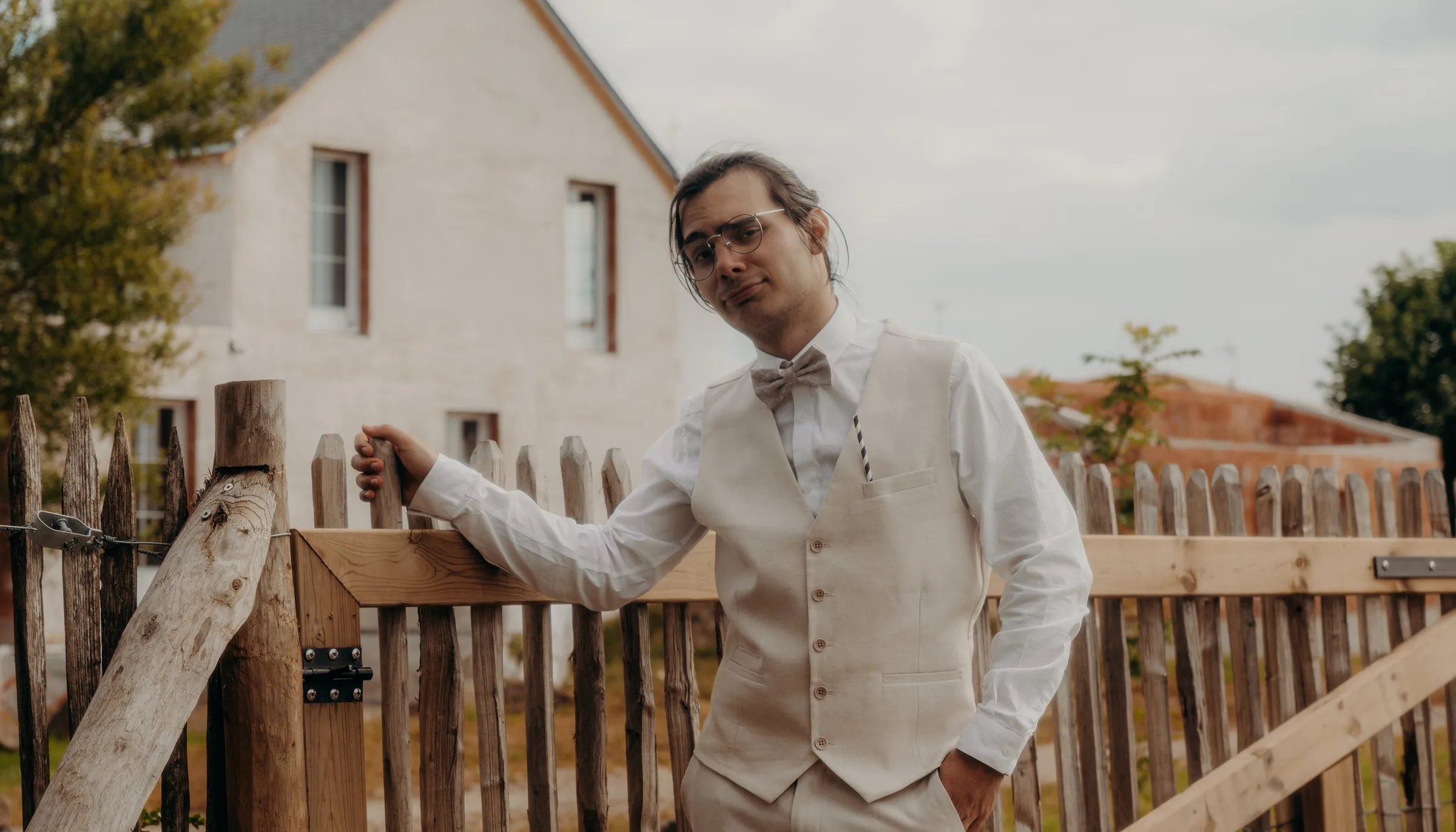 Un invité en nœud papillon, appuyé contre une barrière