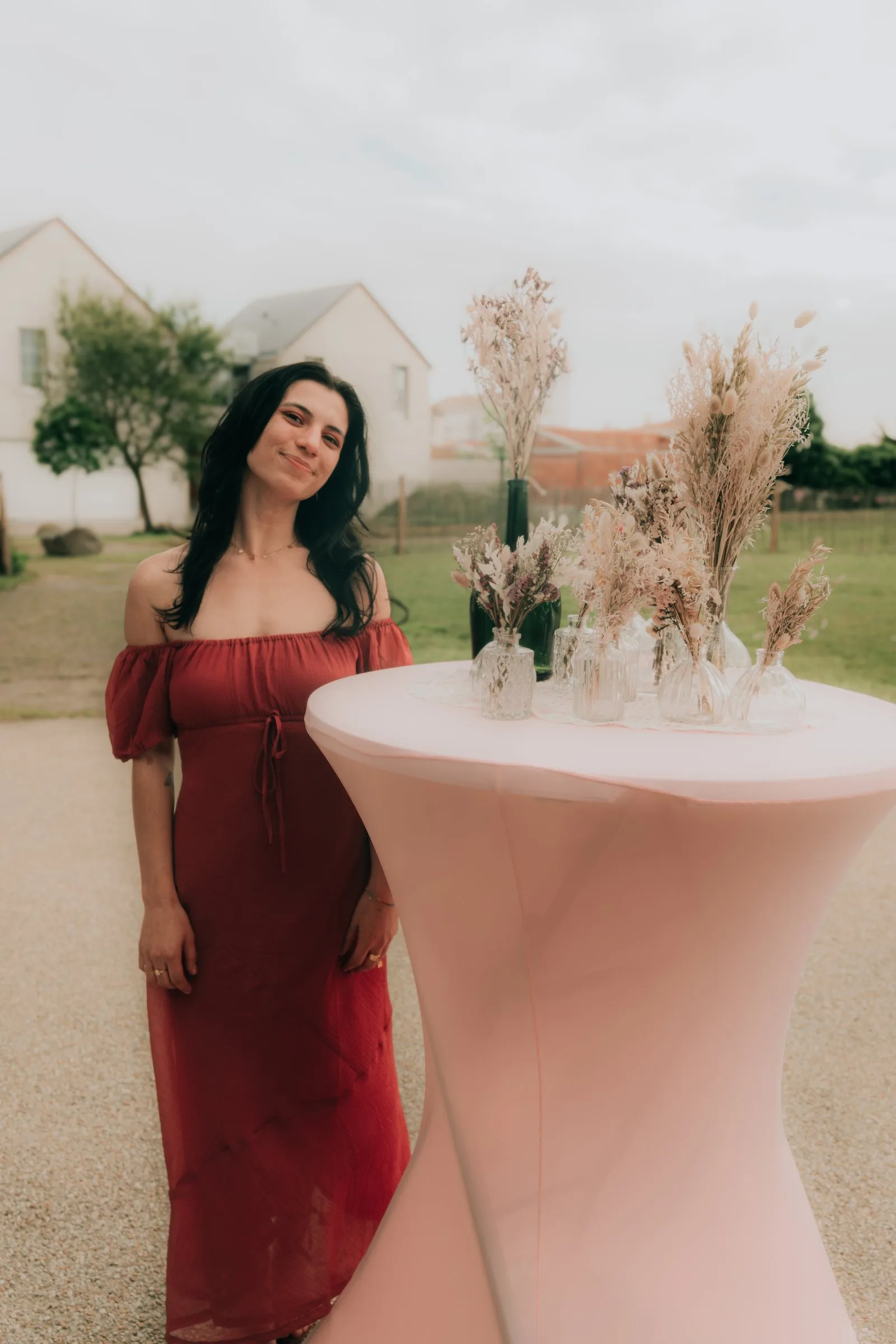 Une invitée en robe rouge près d’un mange-debout fleuri