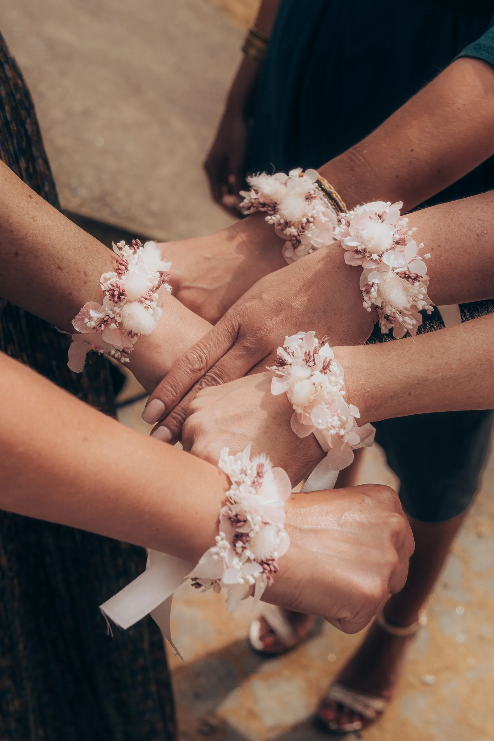 Mains des invitées aux bracelets fleuris