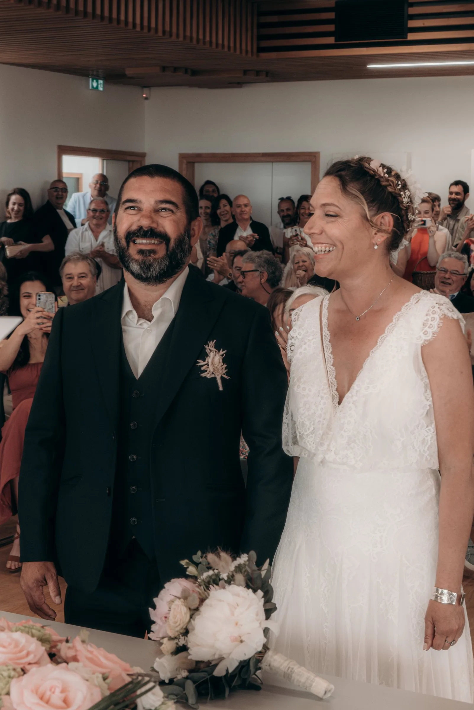Les mariés rient devant leurs invités