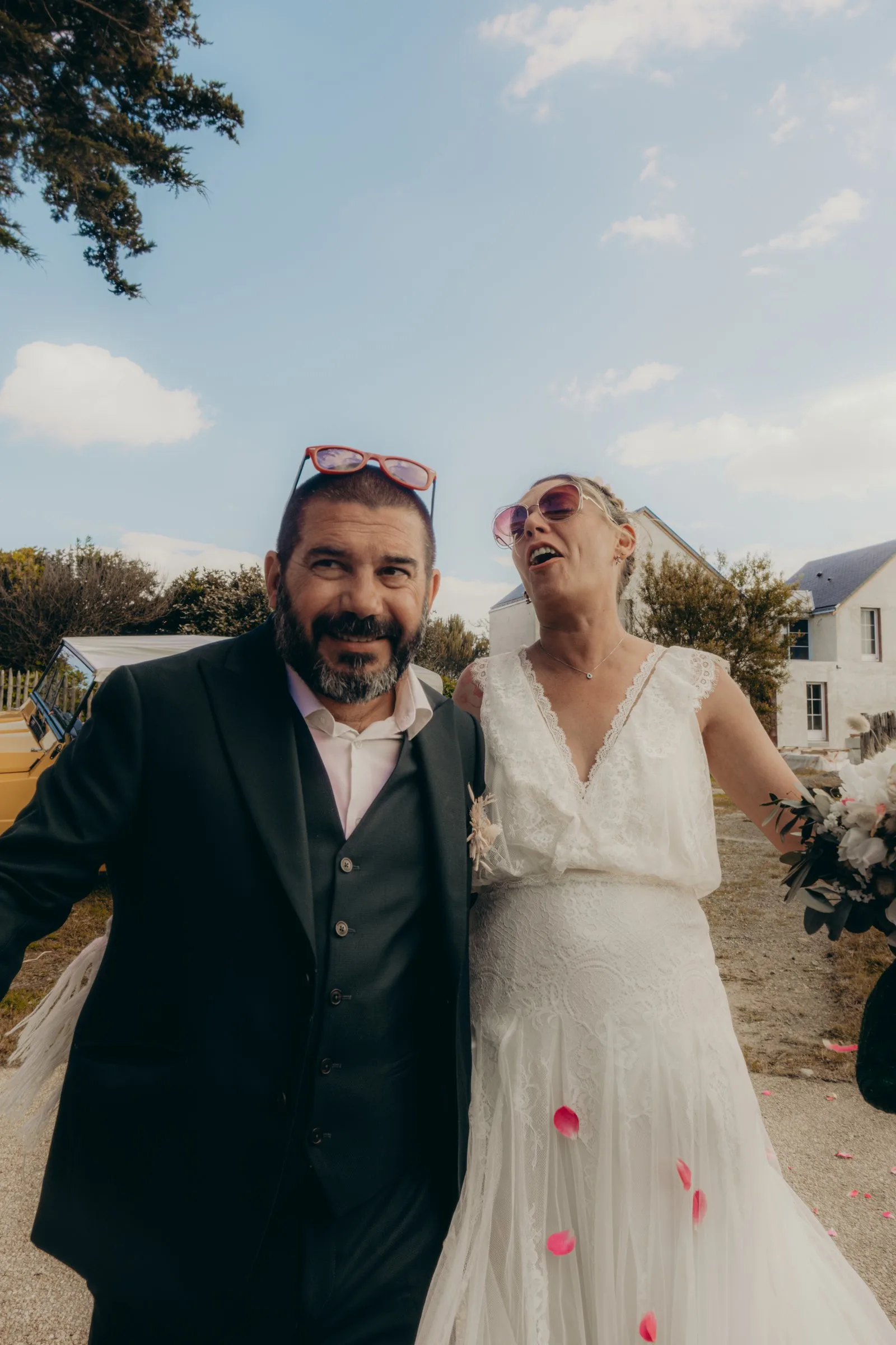 Les mariés rient sous les pétales