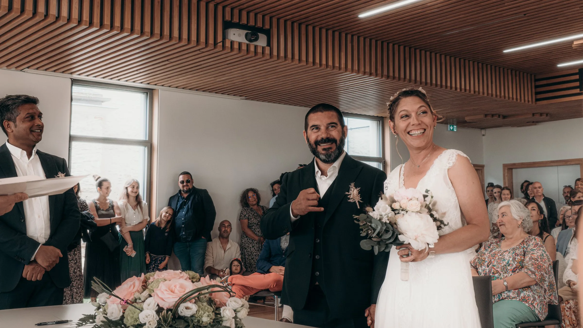 Les mariés sourient à leurs invités dans la salle des mariages