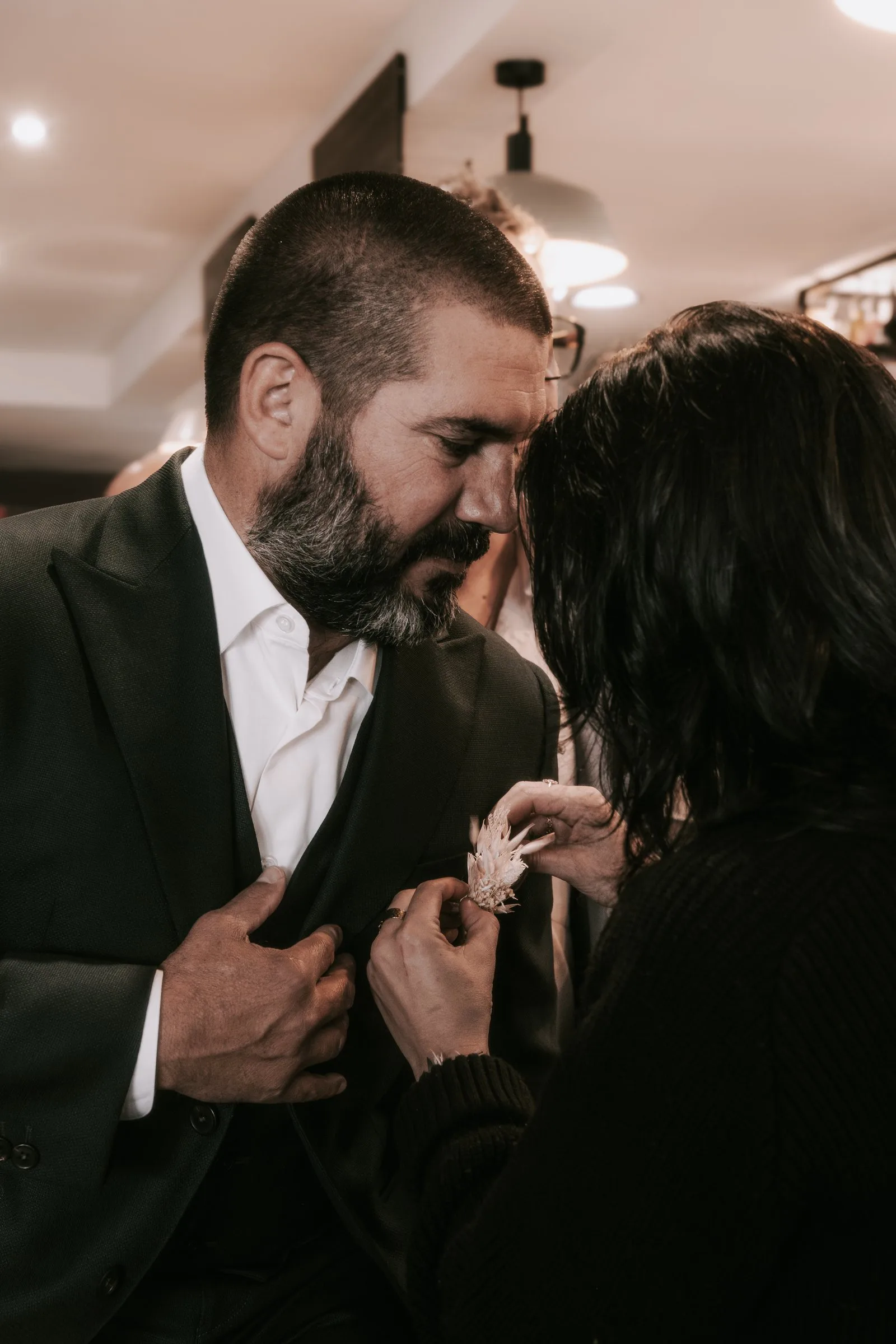 Une proche épingle la boutonnière du marié