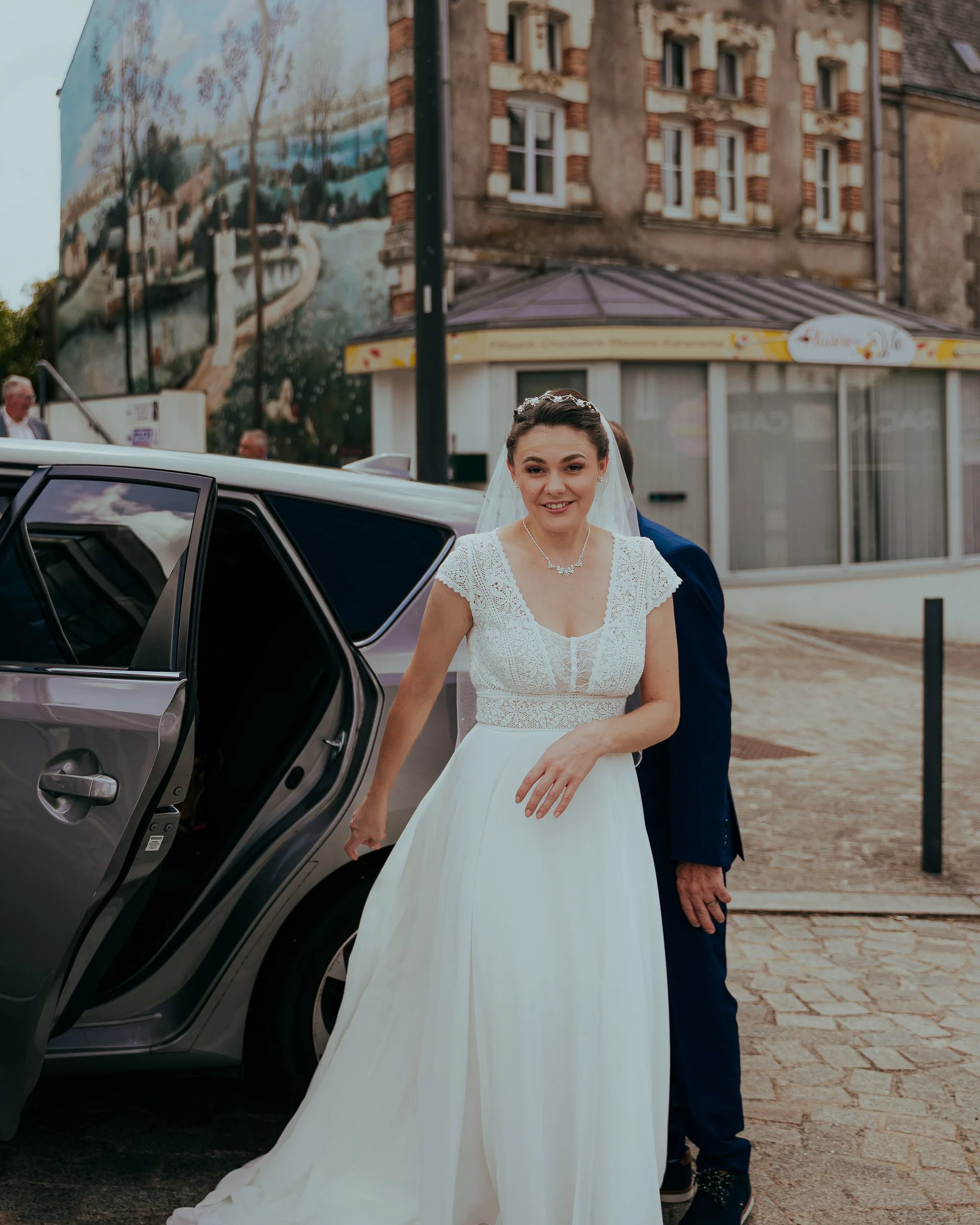 La mariée sort de la voiture devant la mairie