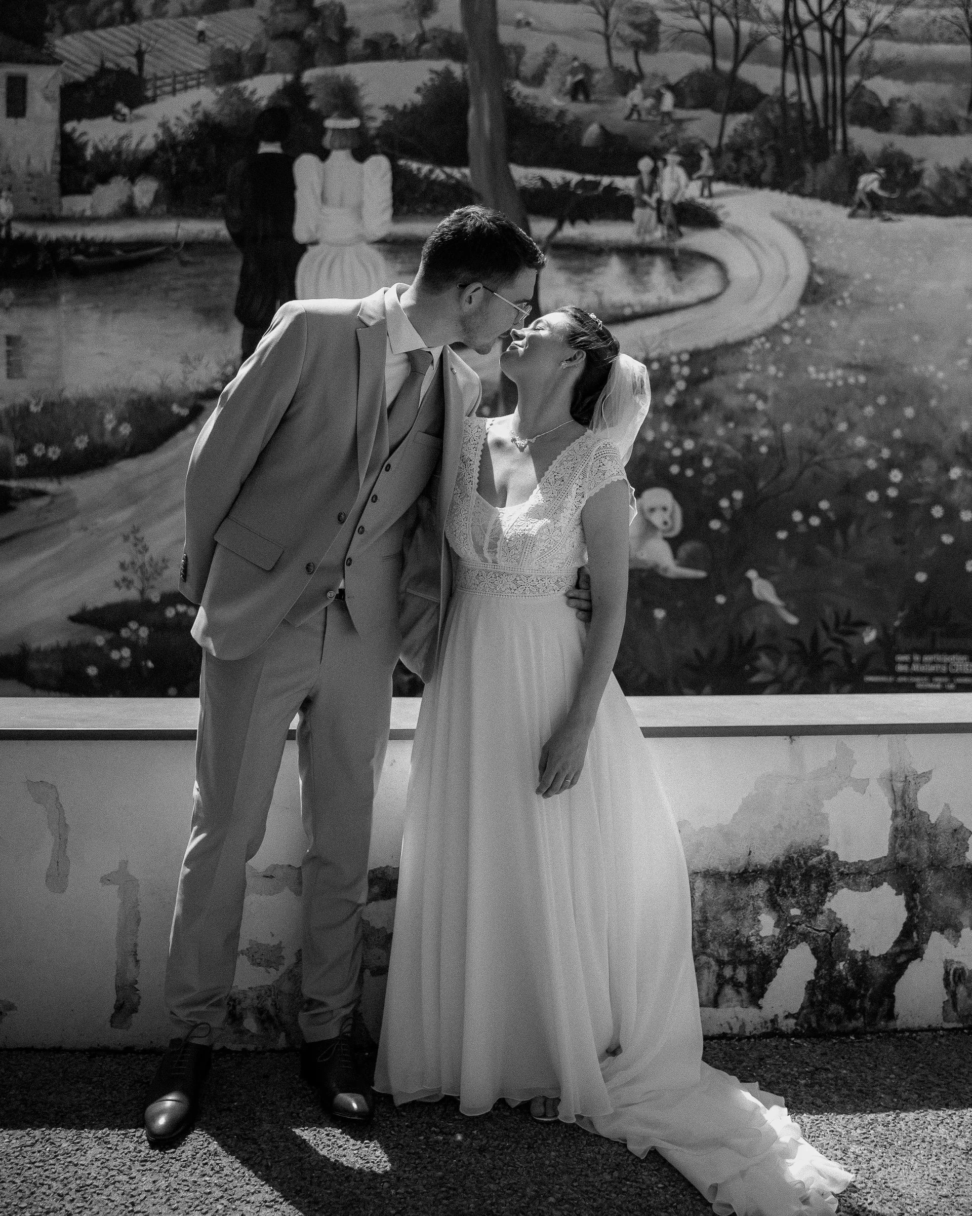 Les mariés devant une fresque murale, en noir et blanc