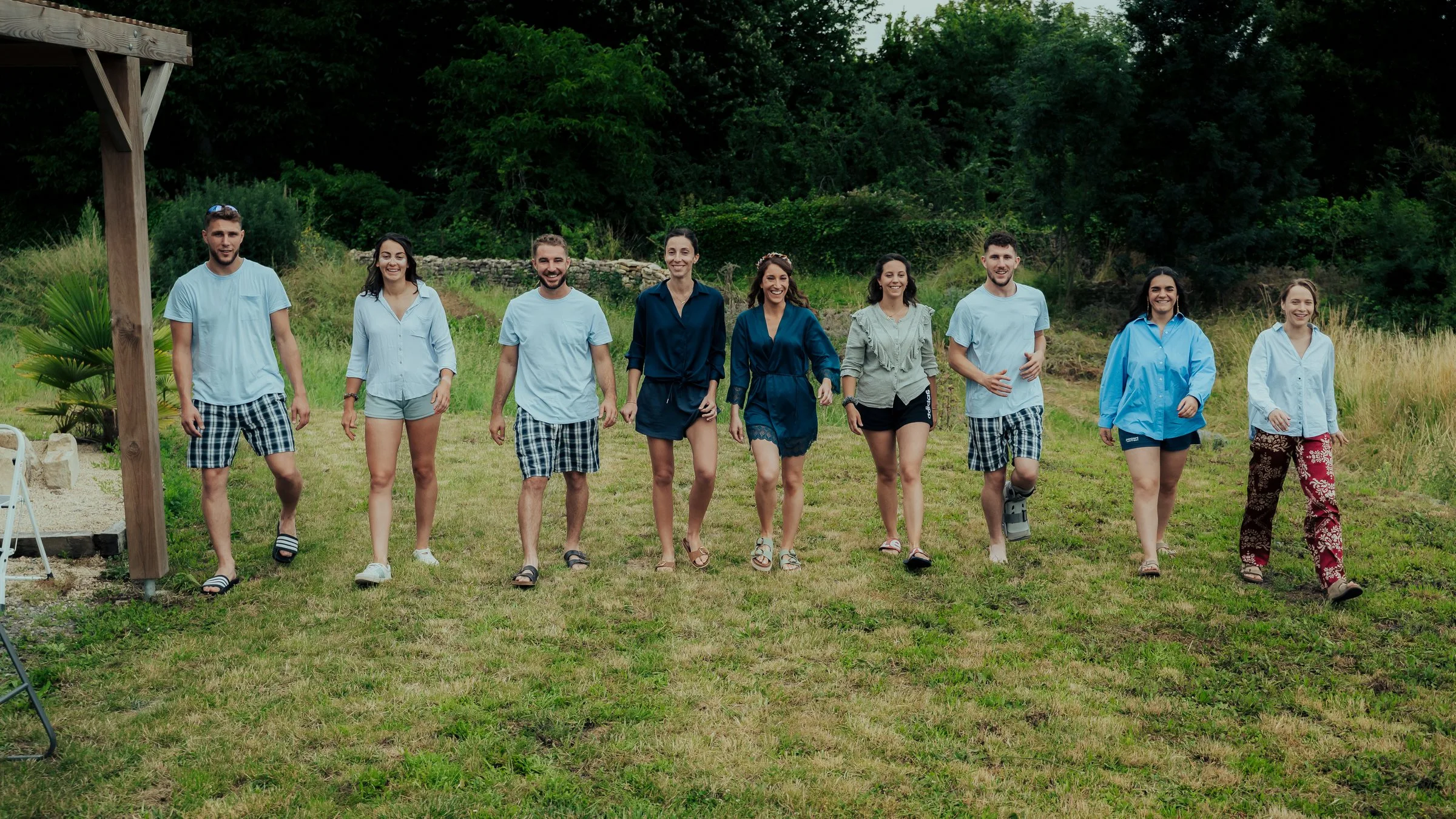 Les amis des mariés, en tenue du matin, avancent dans l’herbe