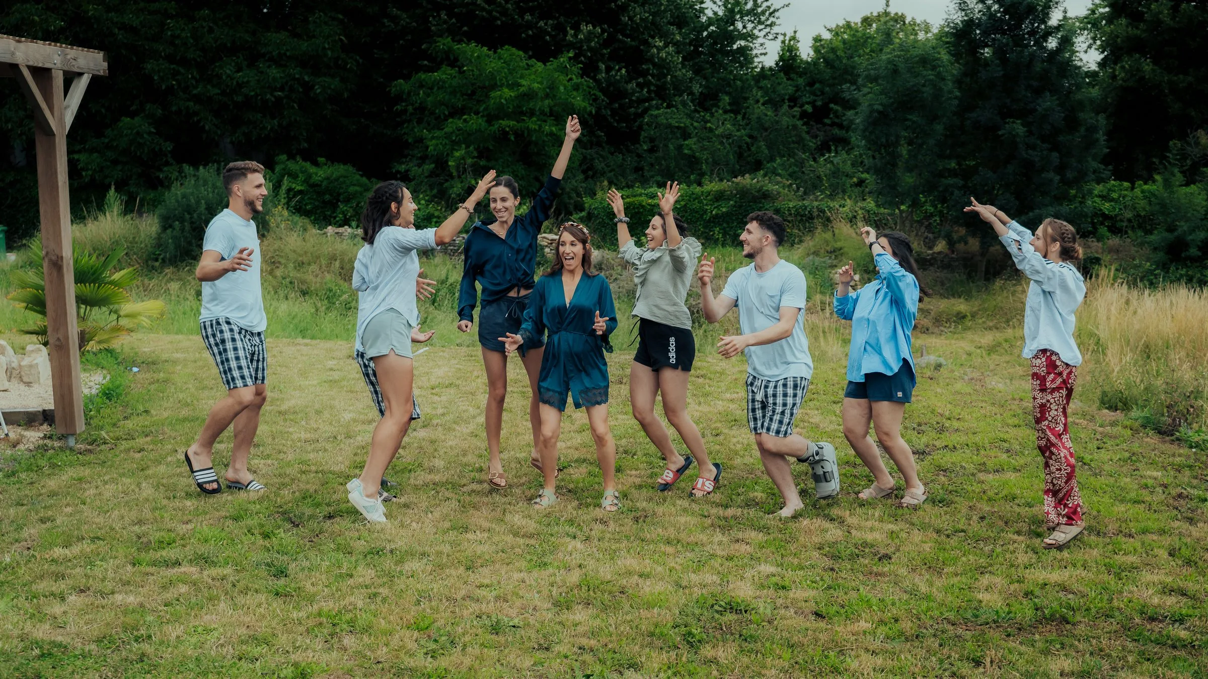 Les amis des mariés sautent de joie dans l’herbe