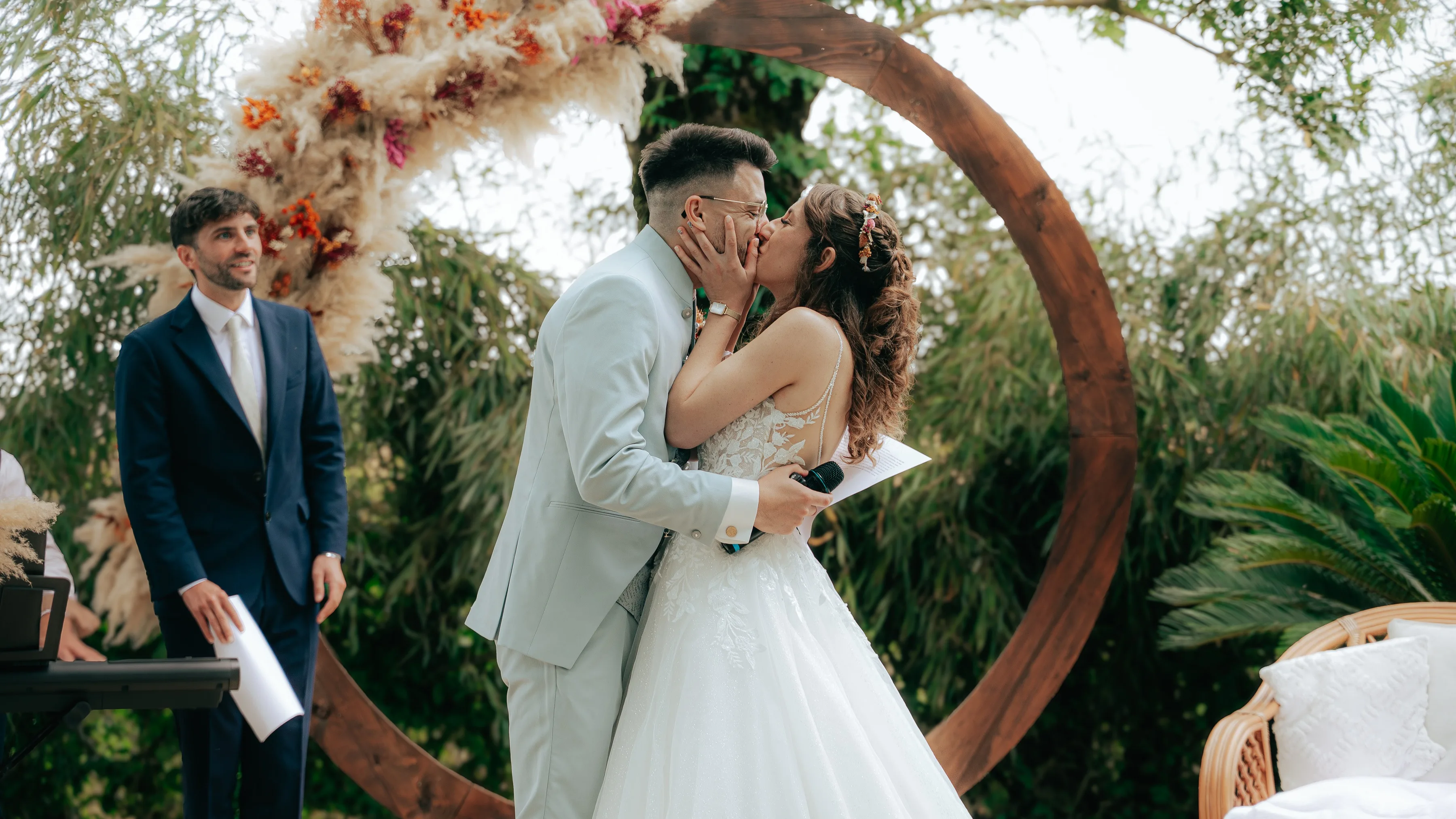 Baiser sous l'arche de fleurs séchées pendant la cérémonie laïque