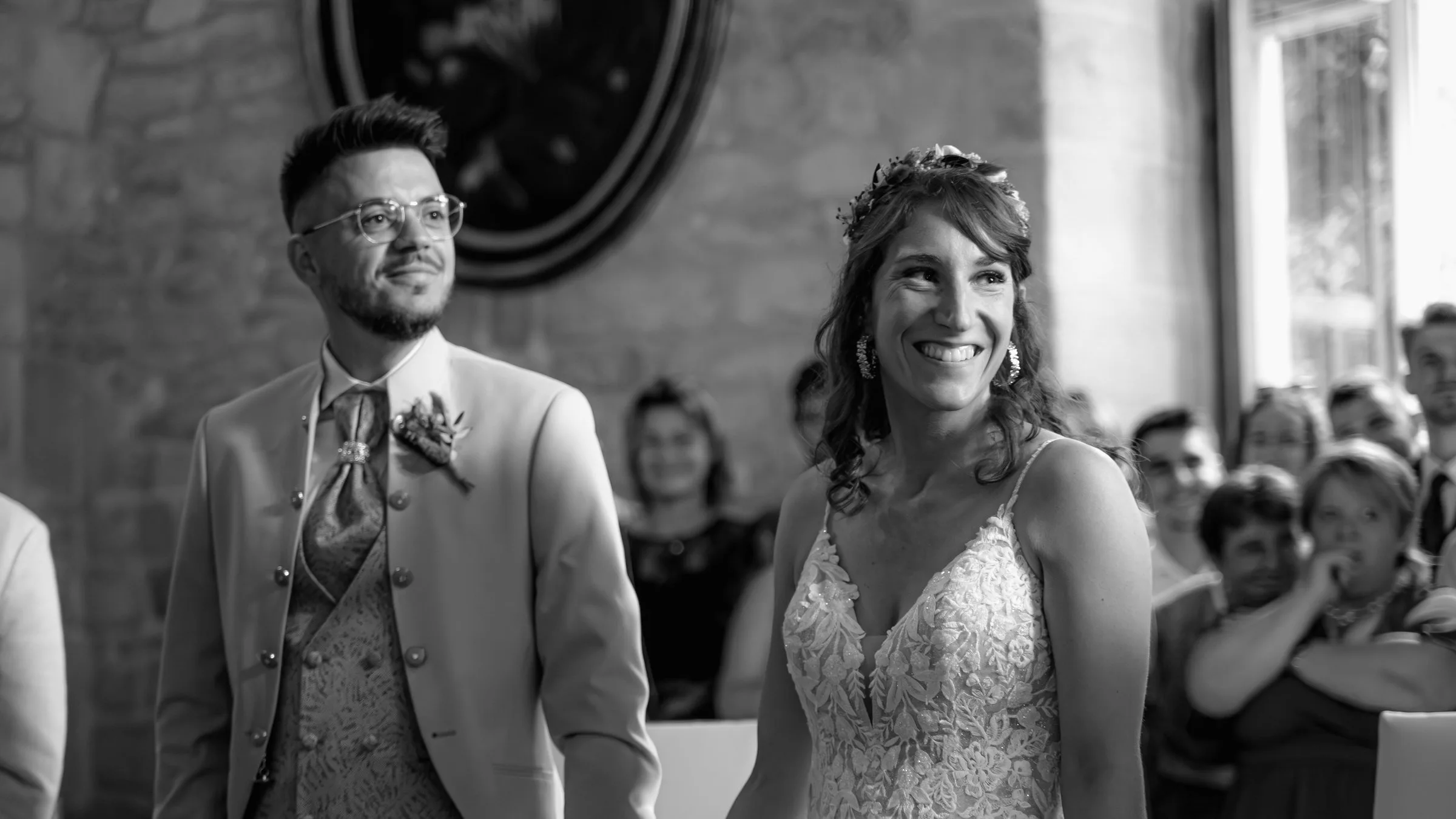 Les mariés rient pendant la cérémonie, en noir et blanc