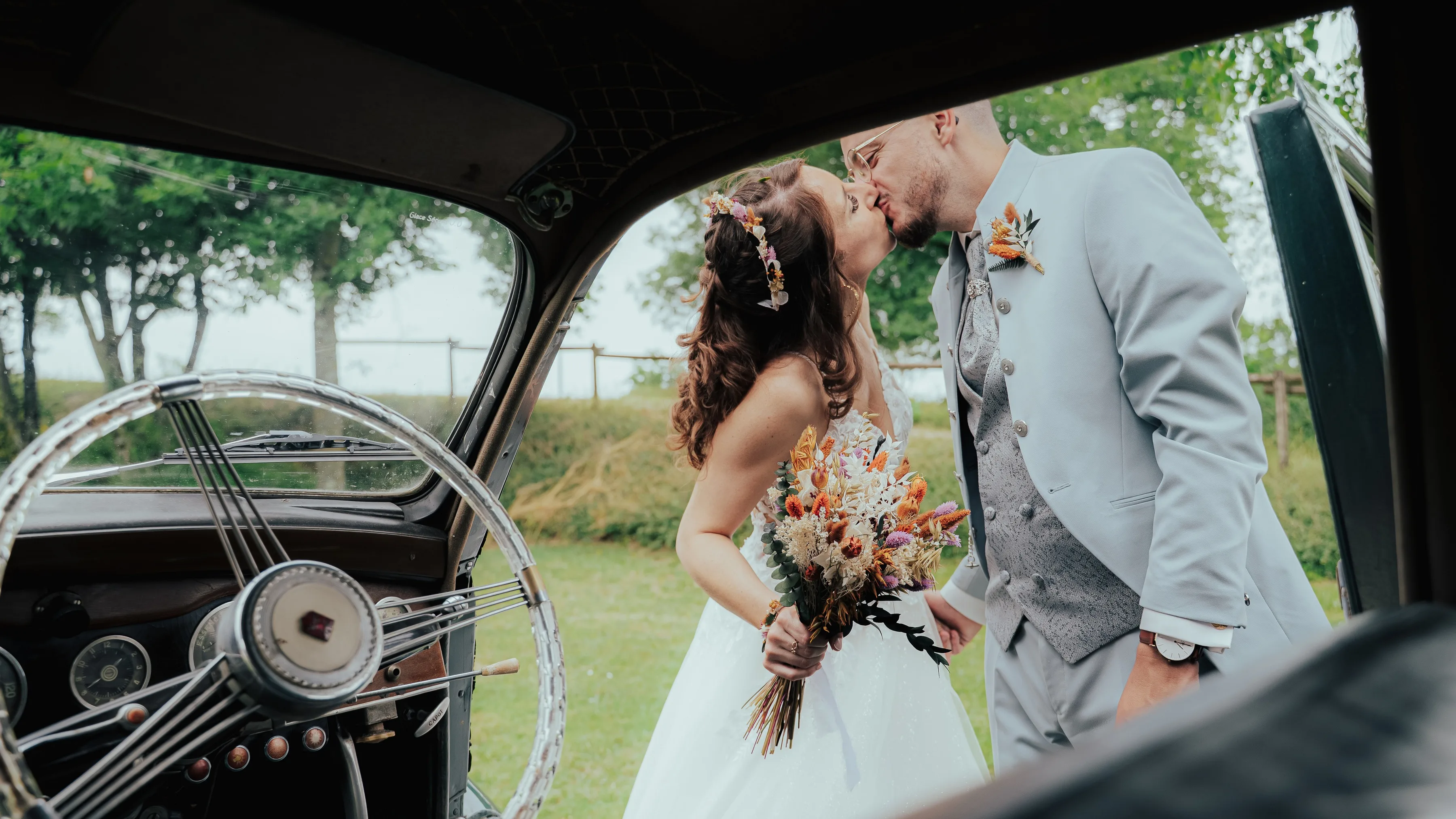 Les mariés dans la voiture ancienne, vus à travers la vitre