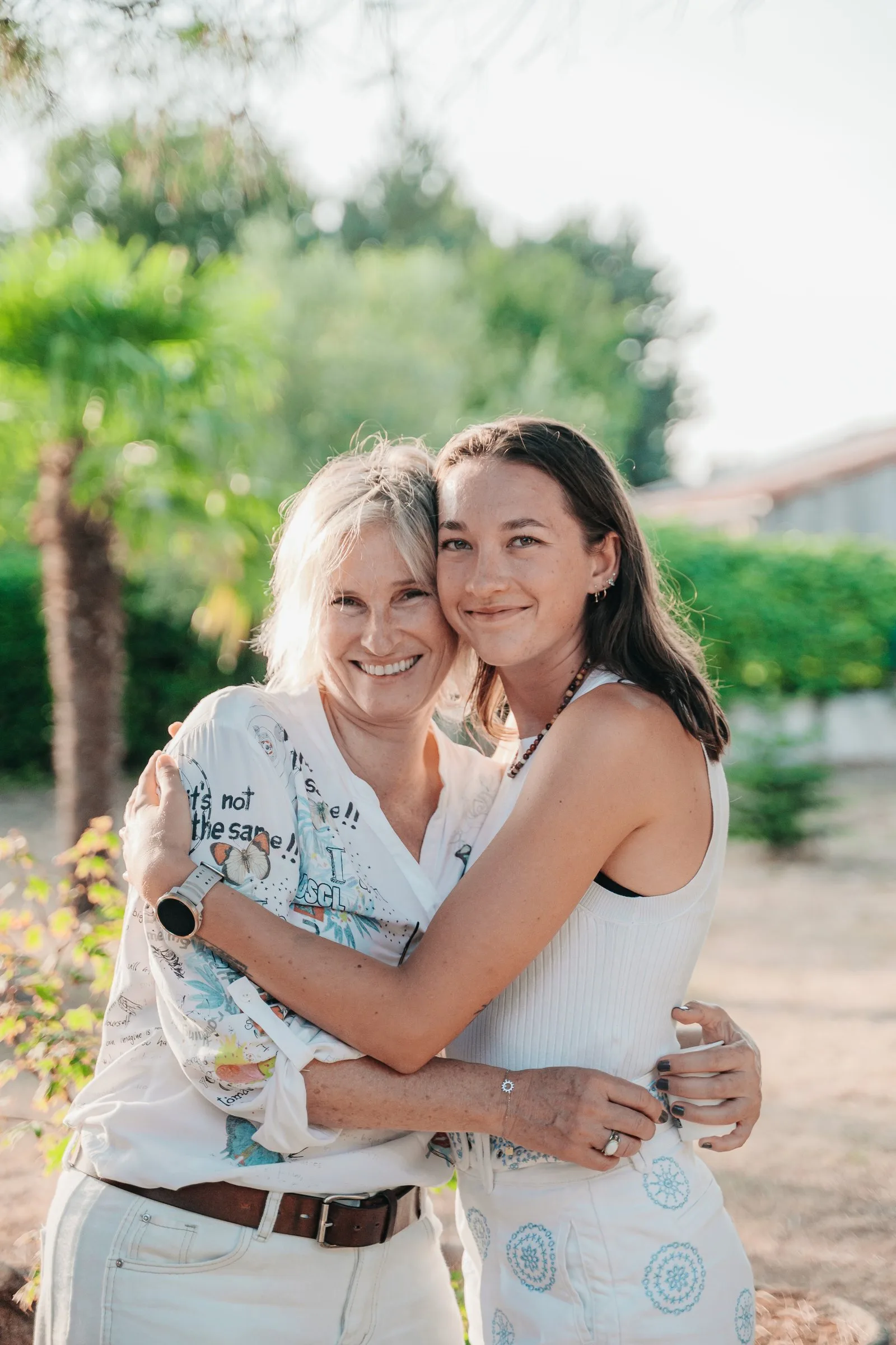Deux proches enlacées sourient dans le jardin