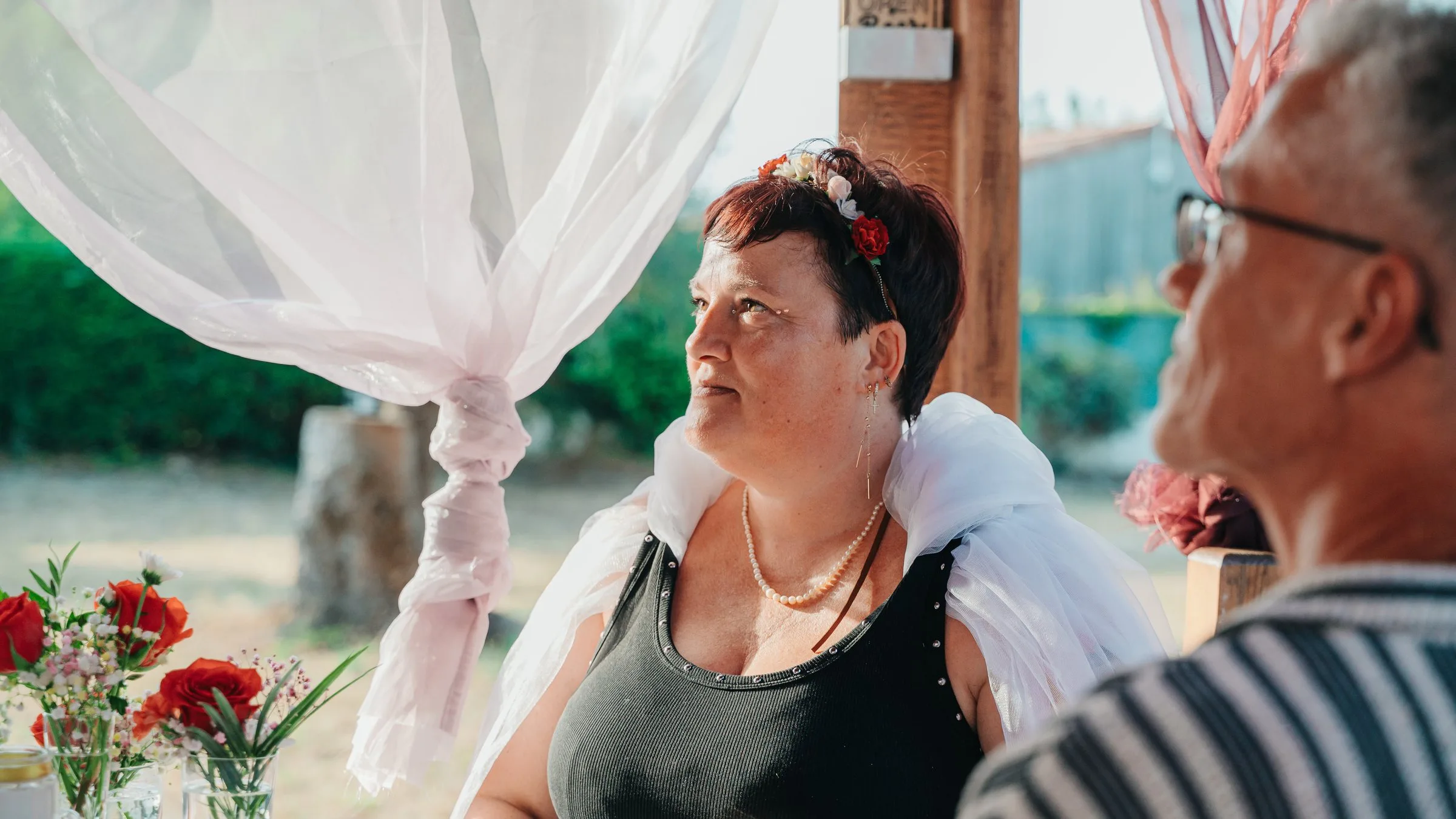 La mariée regarde le marié entre les voilages blancs