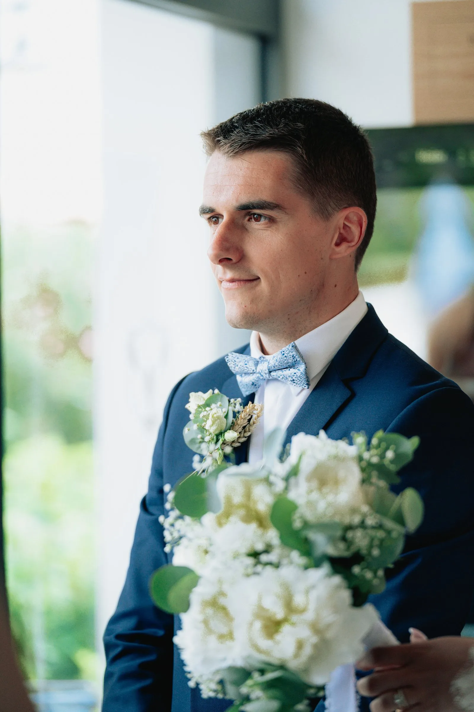 Le marié tient le bouquet de la mariée