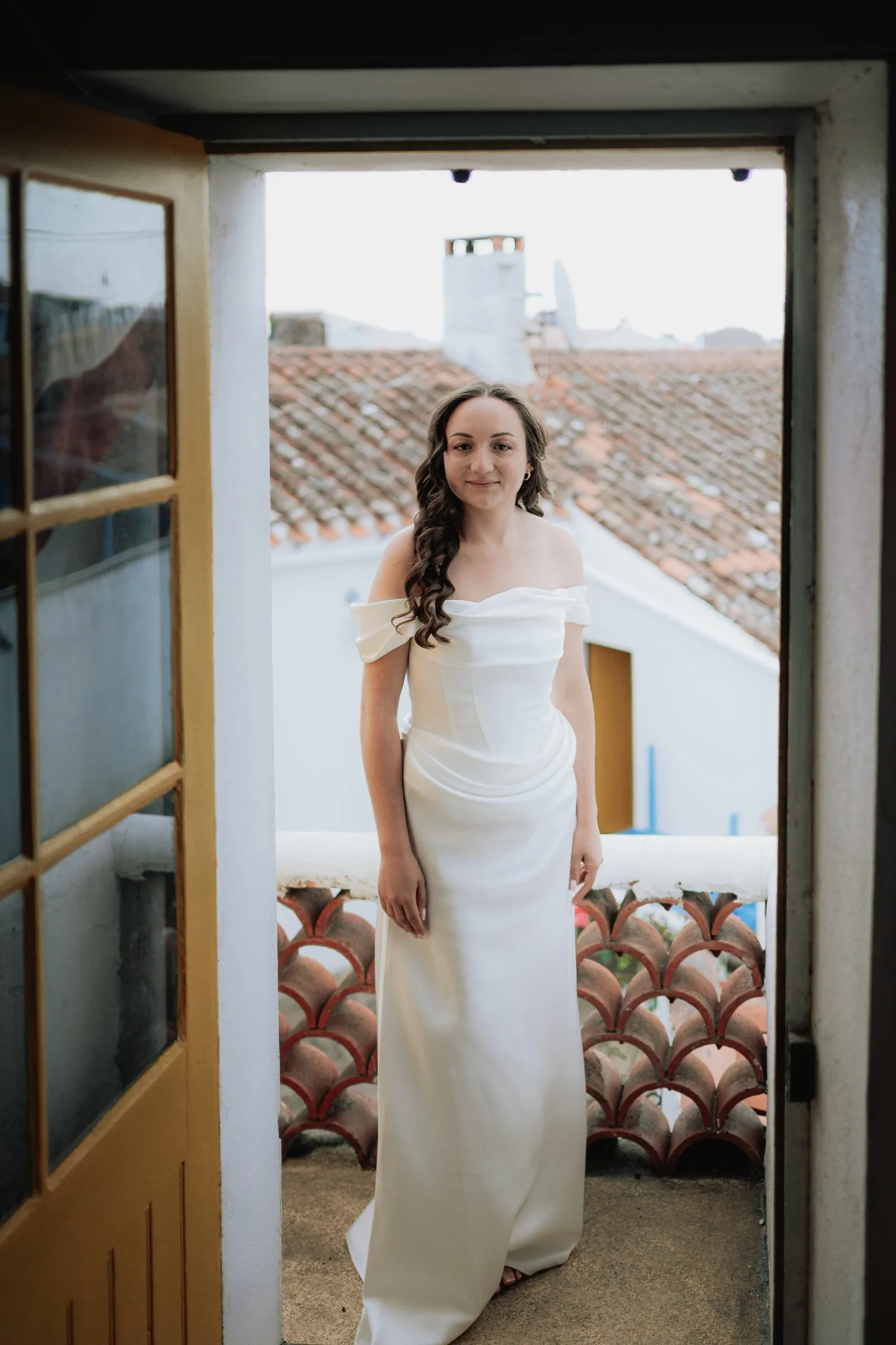 La mariée prête, dans l’encadrement de la porte-fenêtre
