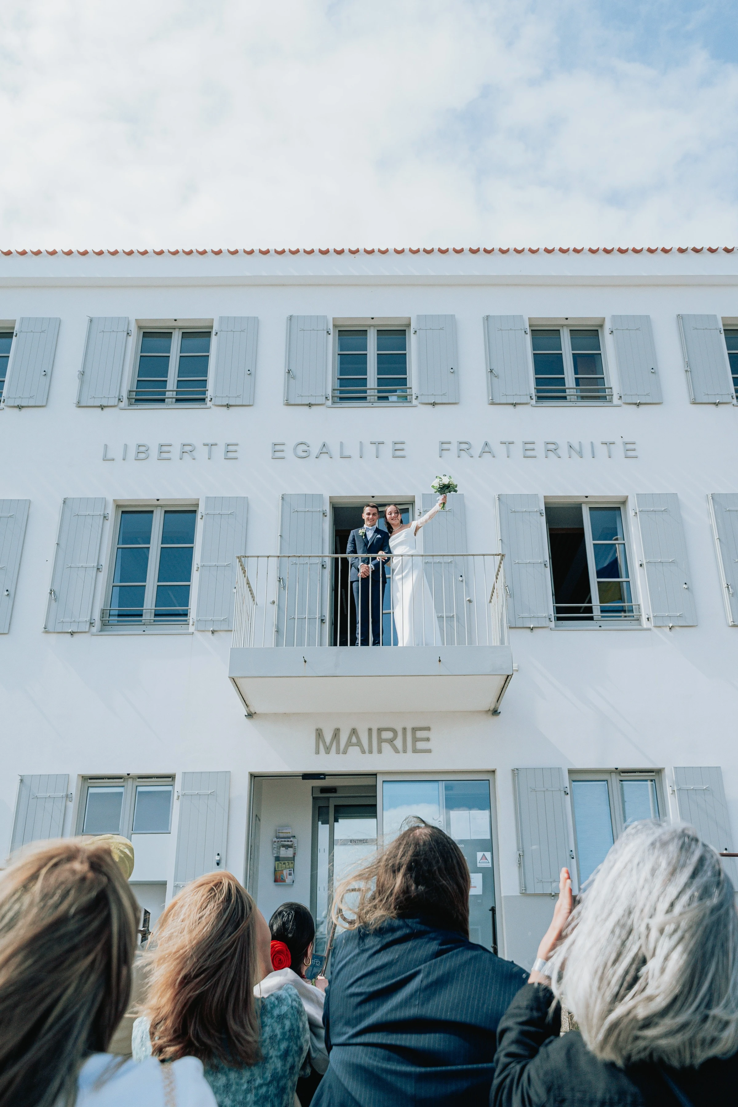 Les mariés saluent leurs invités depuis le balcon de la mairie de l’île d’Yeu