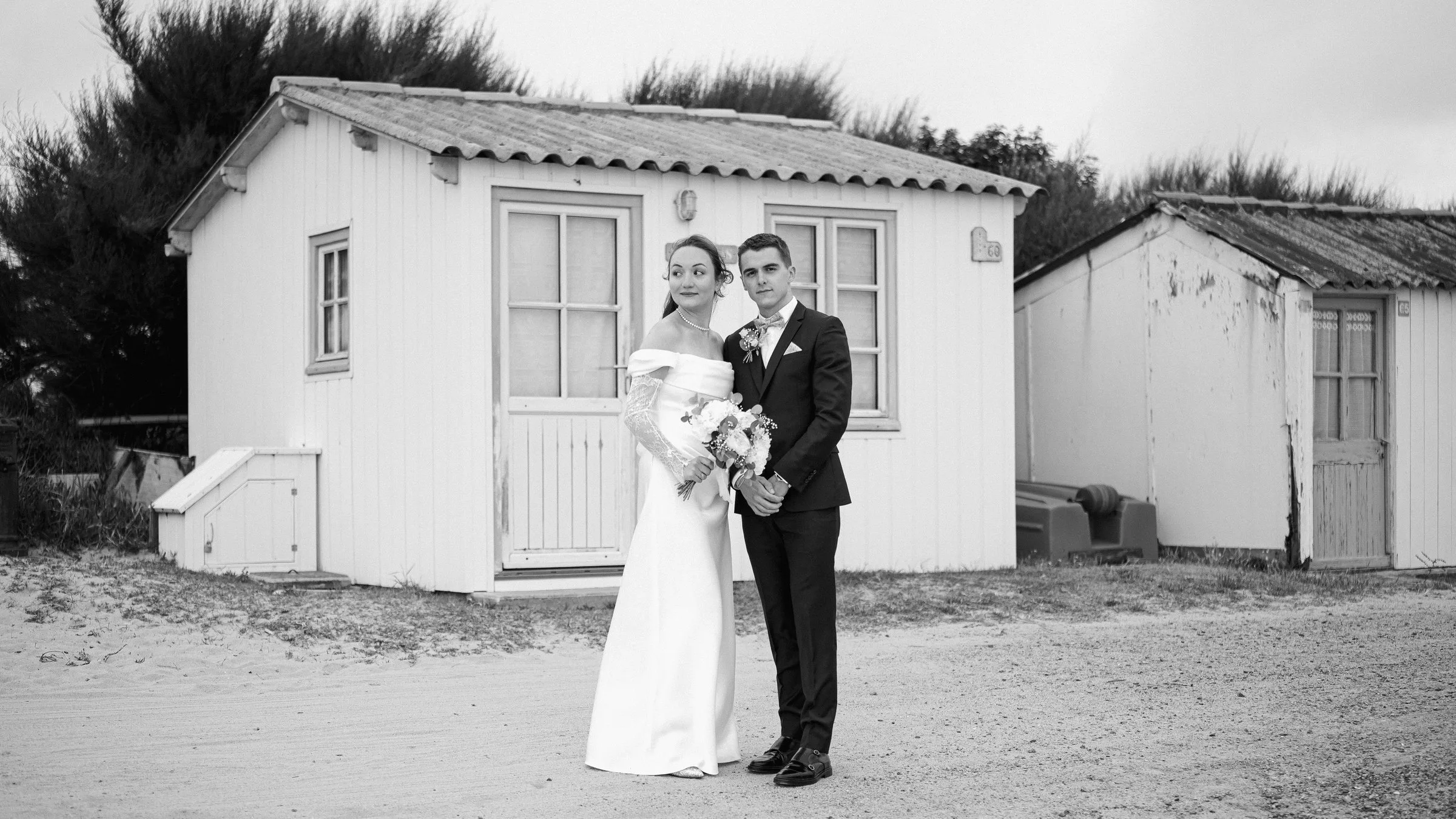 Les mariés devant une cabane de plage, en noir et blanc