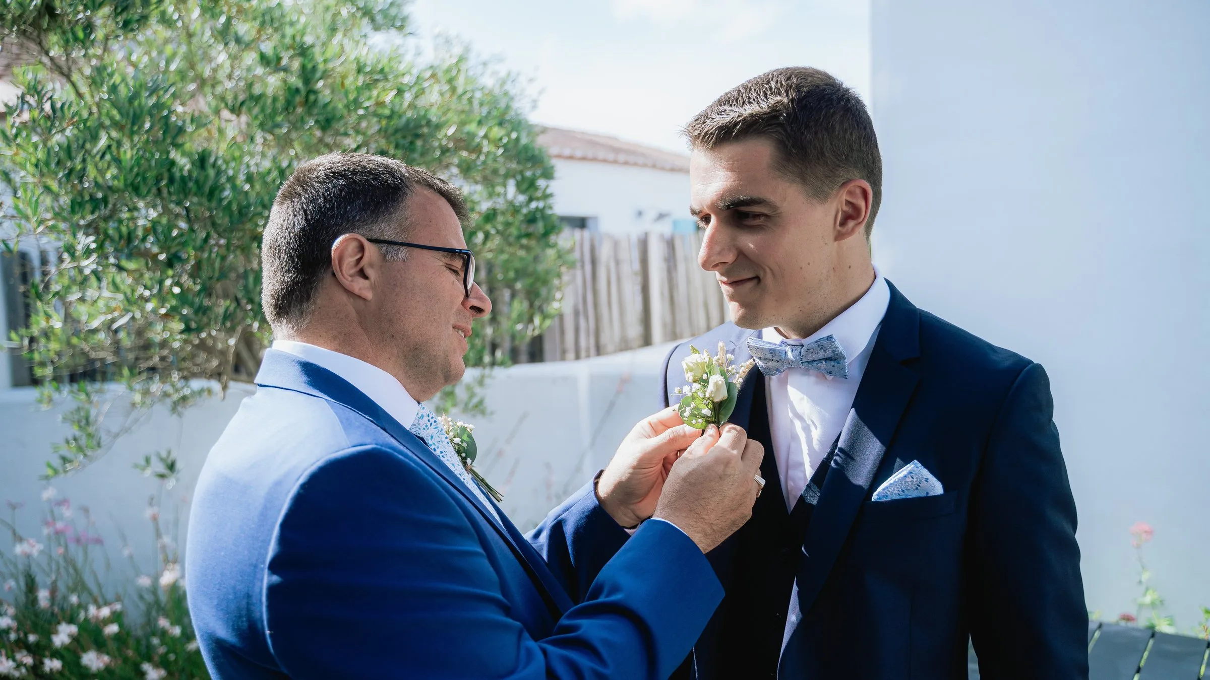 Un proche épingle la boutonnière du marié