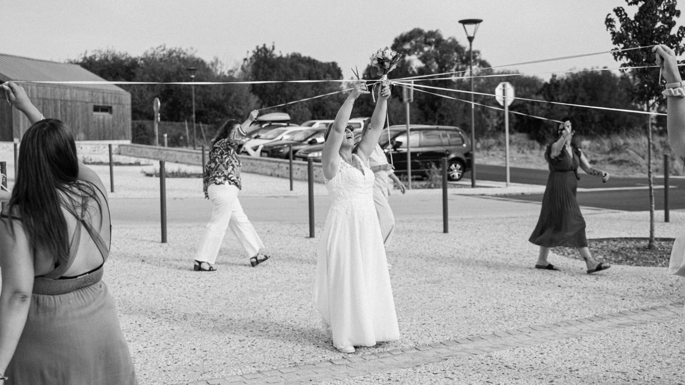 La mariée et le jeu des rubans du bouquet, en noir et blanc