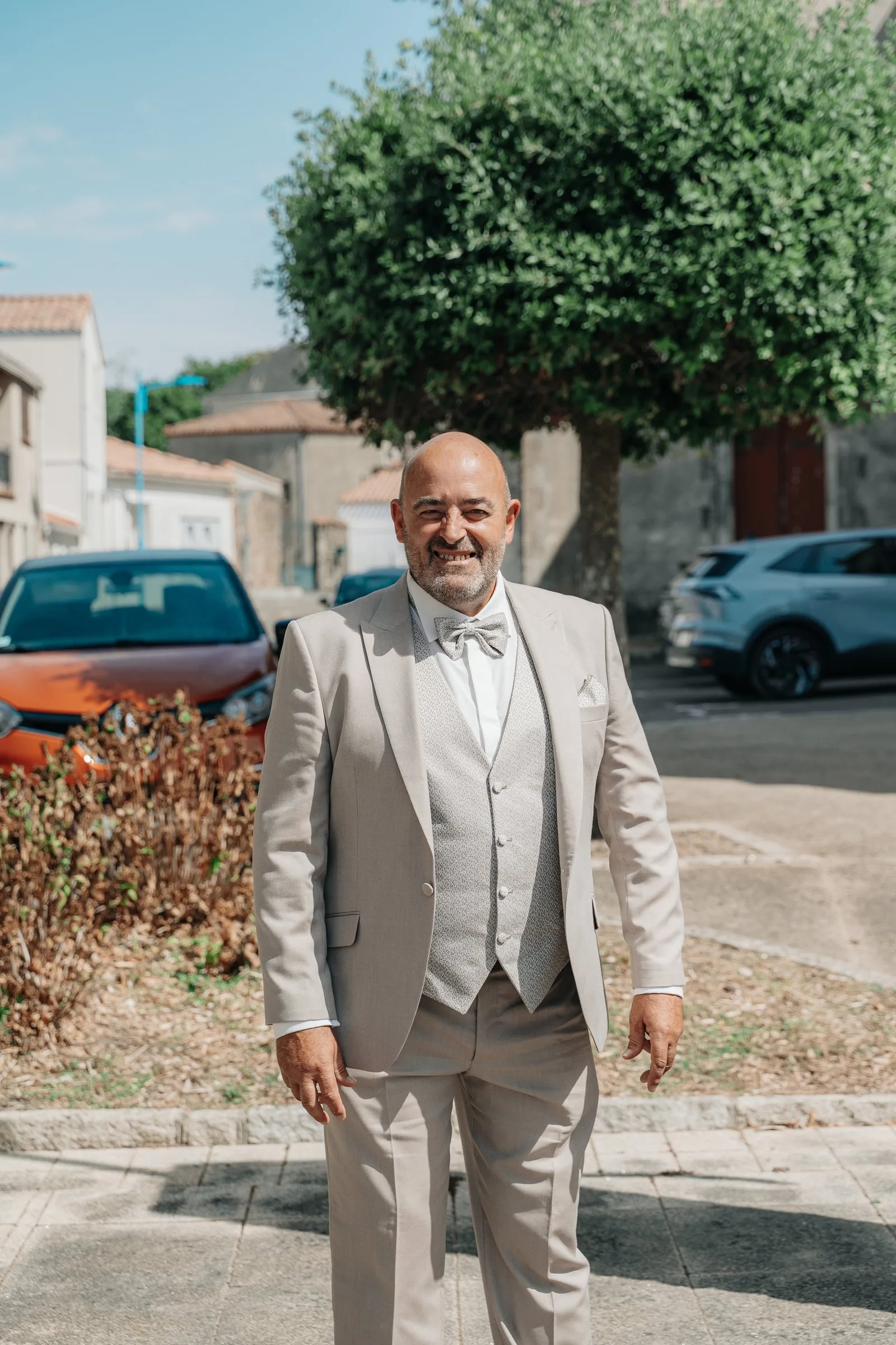 Le marié attend, tout sourire, sur la place