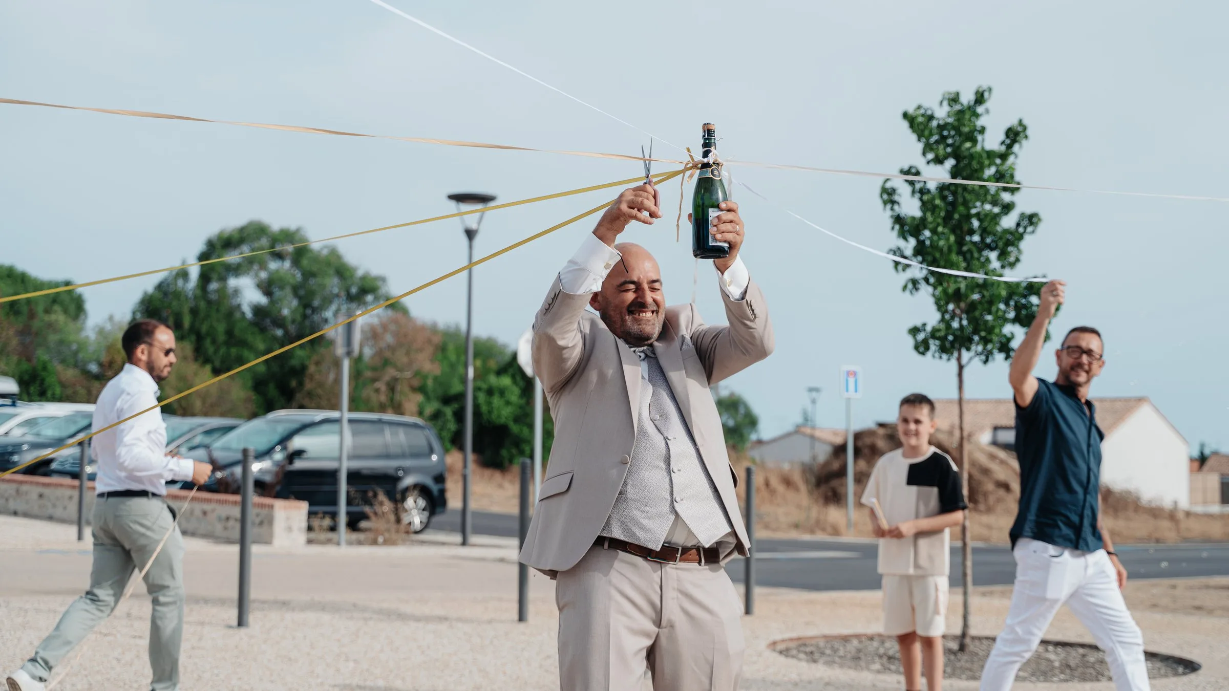 Le marié et le jeu des rubans avec une bouteille de champagne