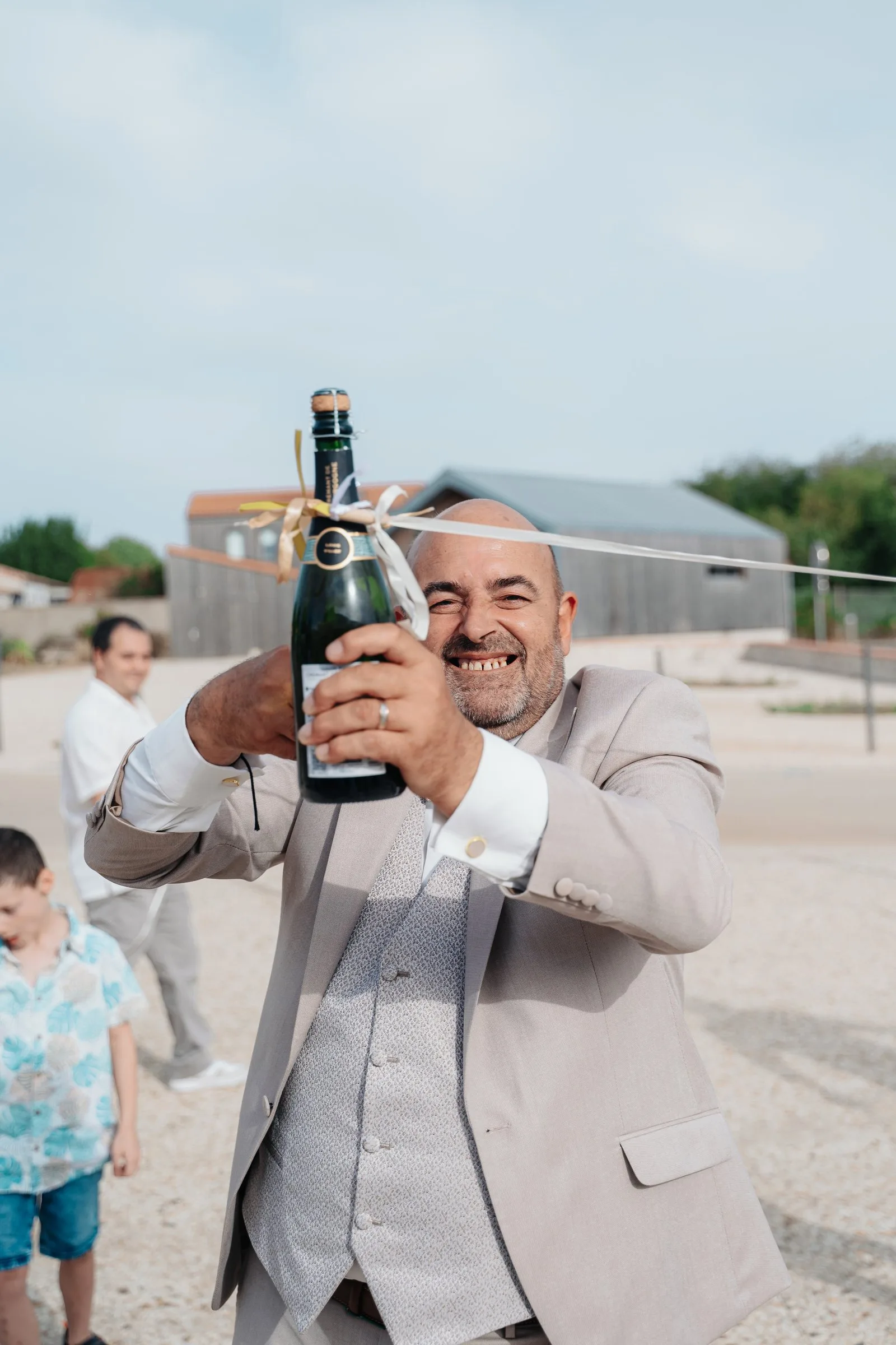 Le marié rit, une bouteille de champagne à la main