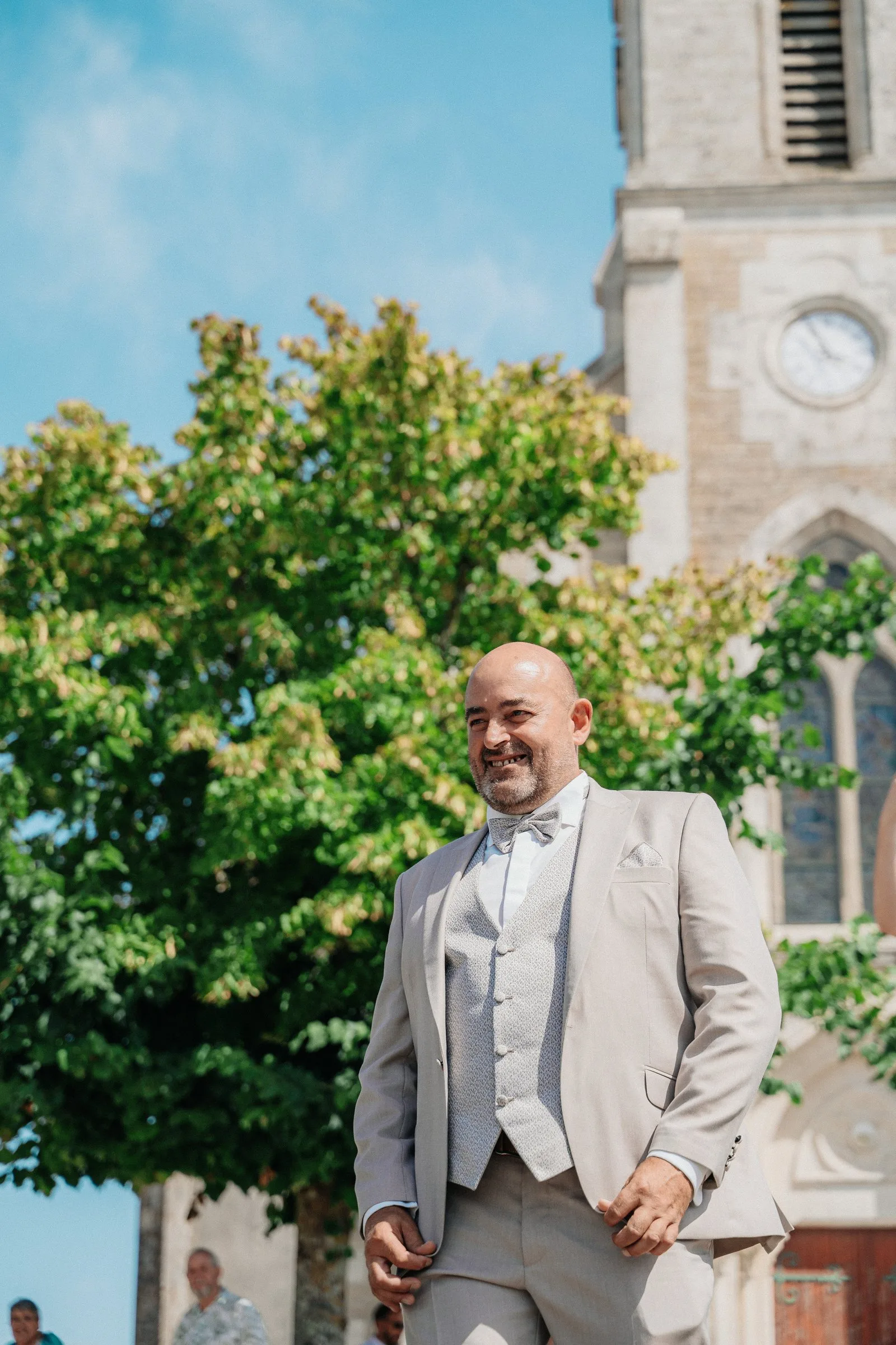 Le marié sourit au pied de l’église