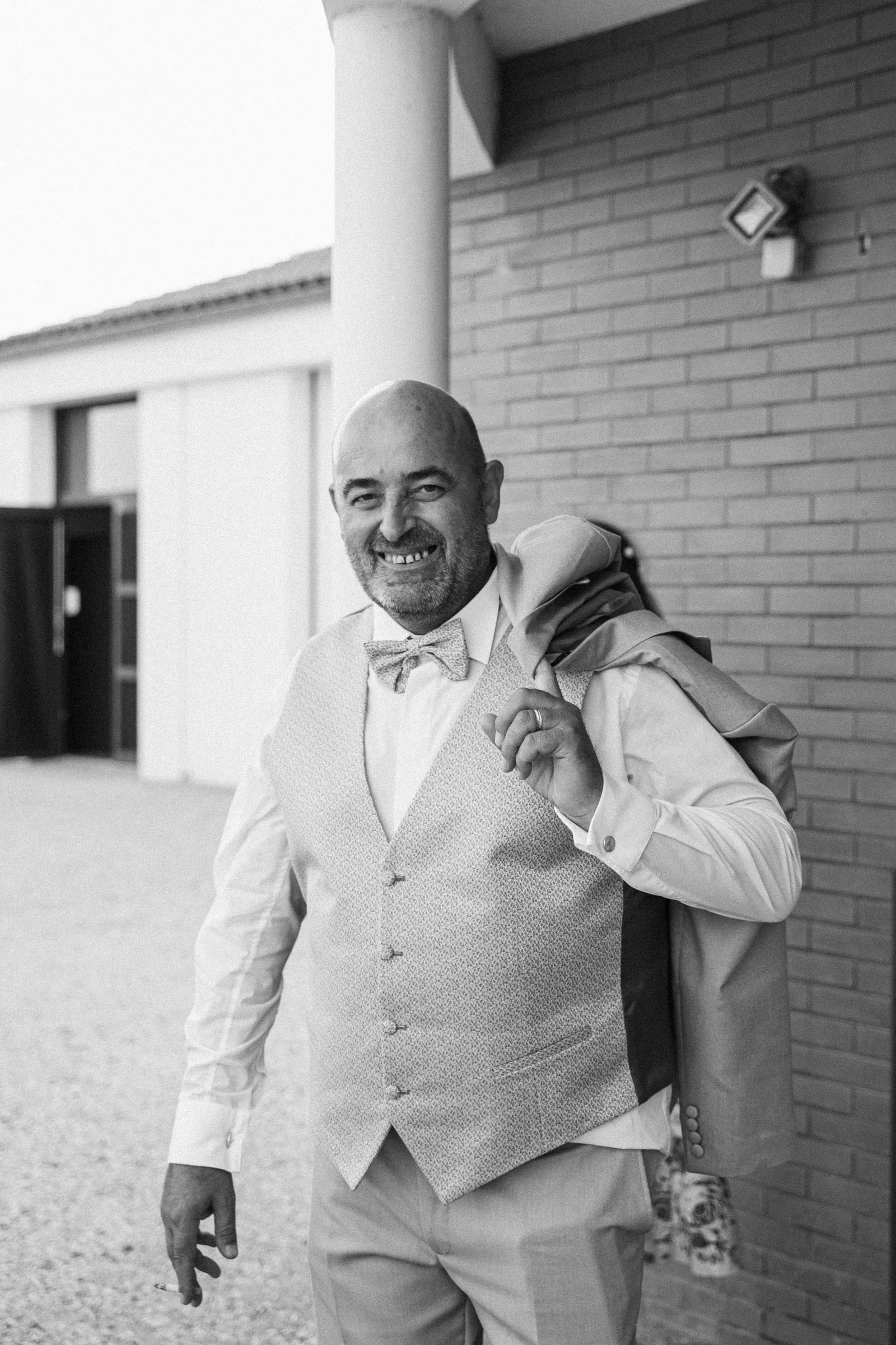 Le marié, veste sur l’épaule, en noir et blanc