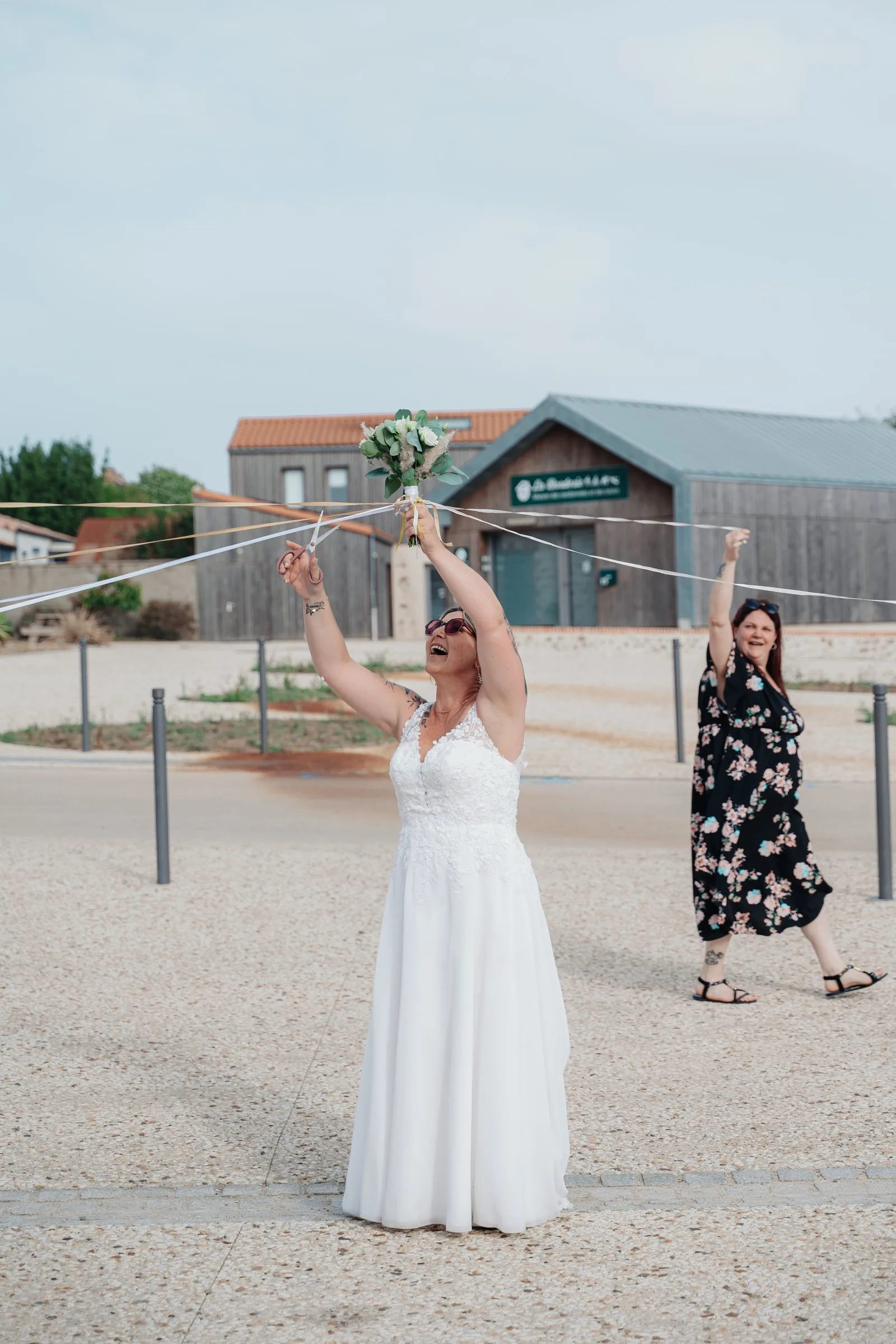 La mariée brandit le bouquet au bout des rubans