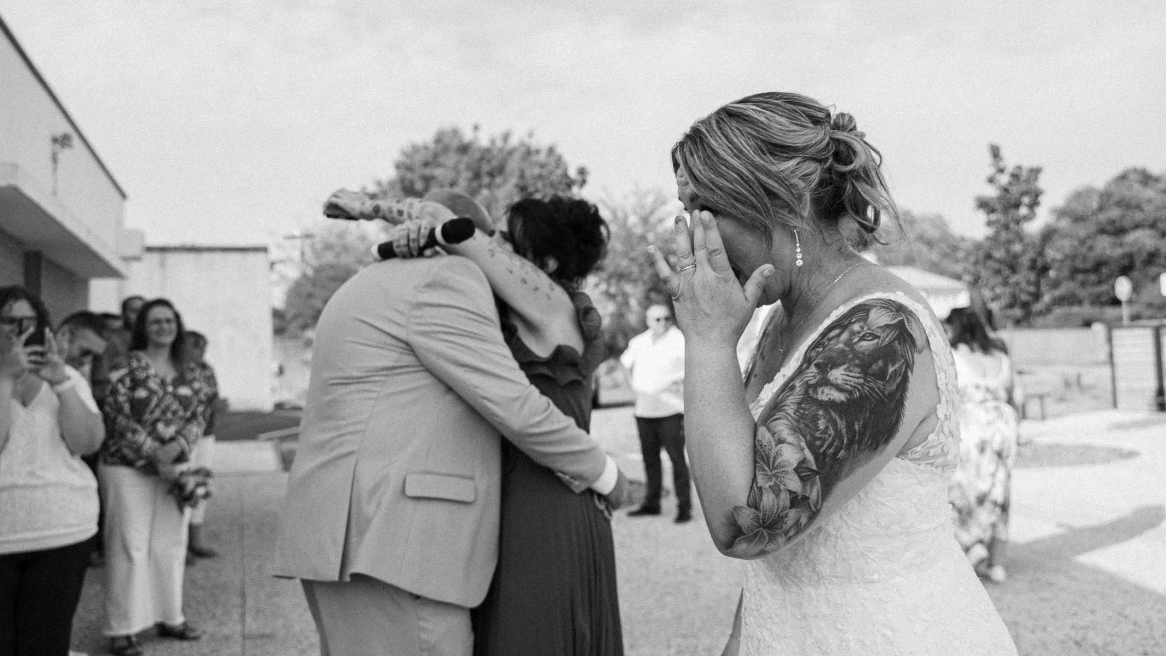 La mariée émue pendant les embrassades, en noir et blanc