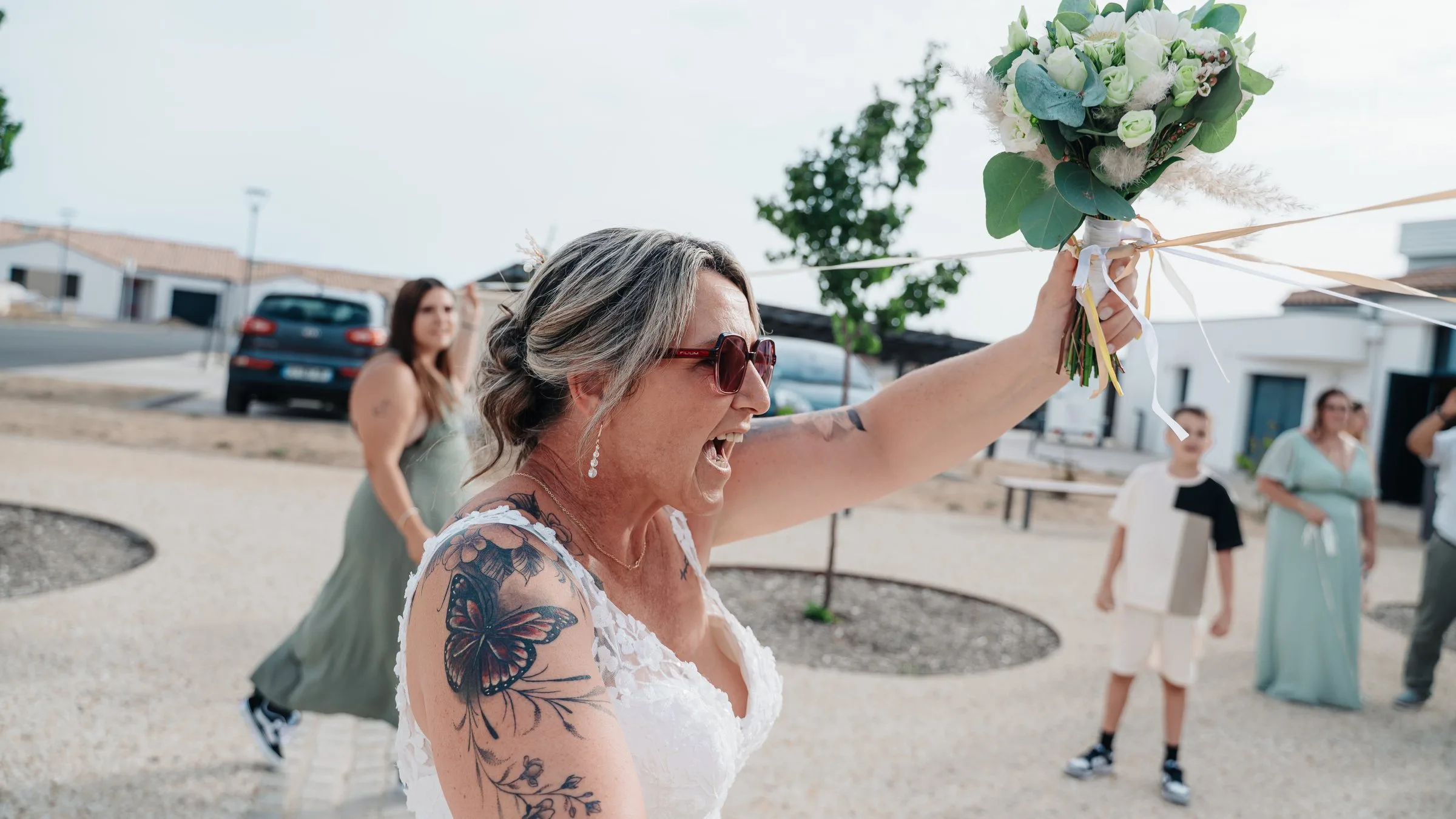 La mariée rit en levant le bouquet