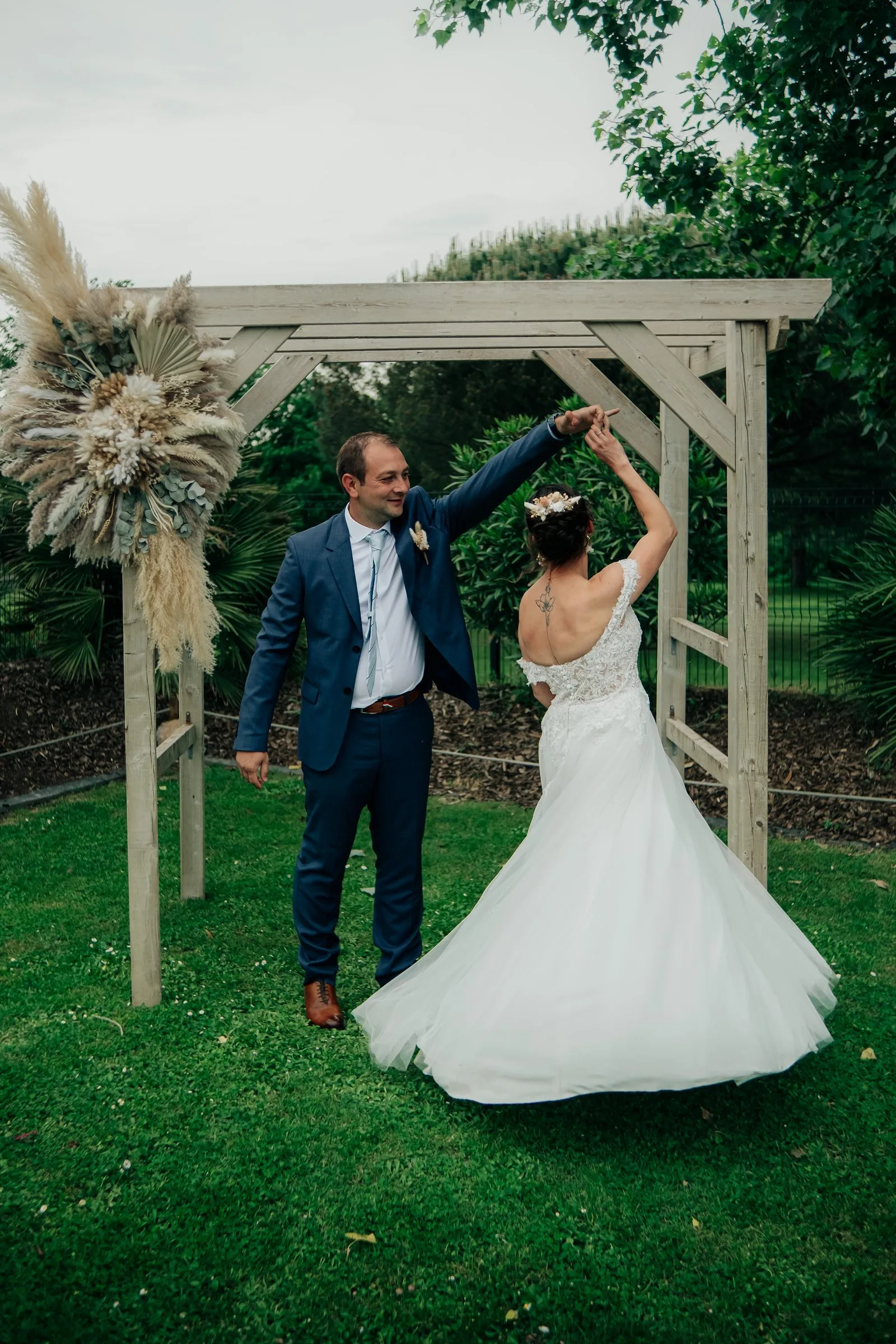 Le marié fait tourner la mariée sous la pergola