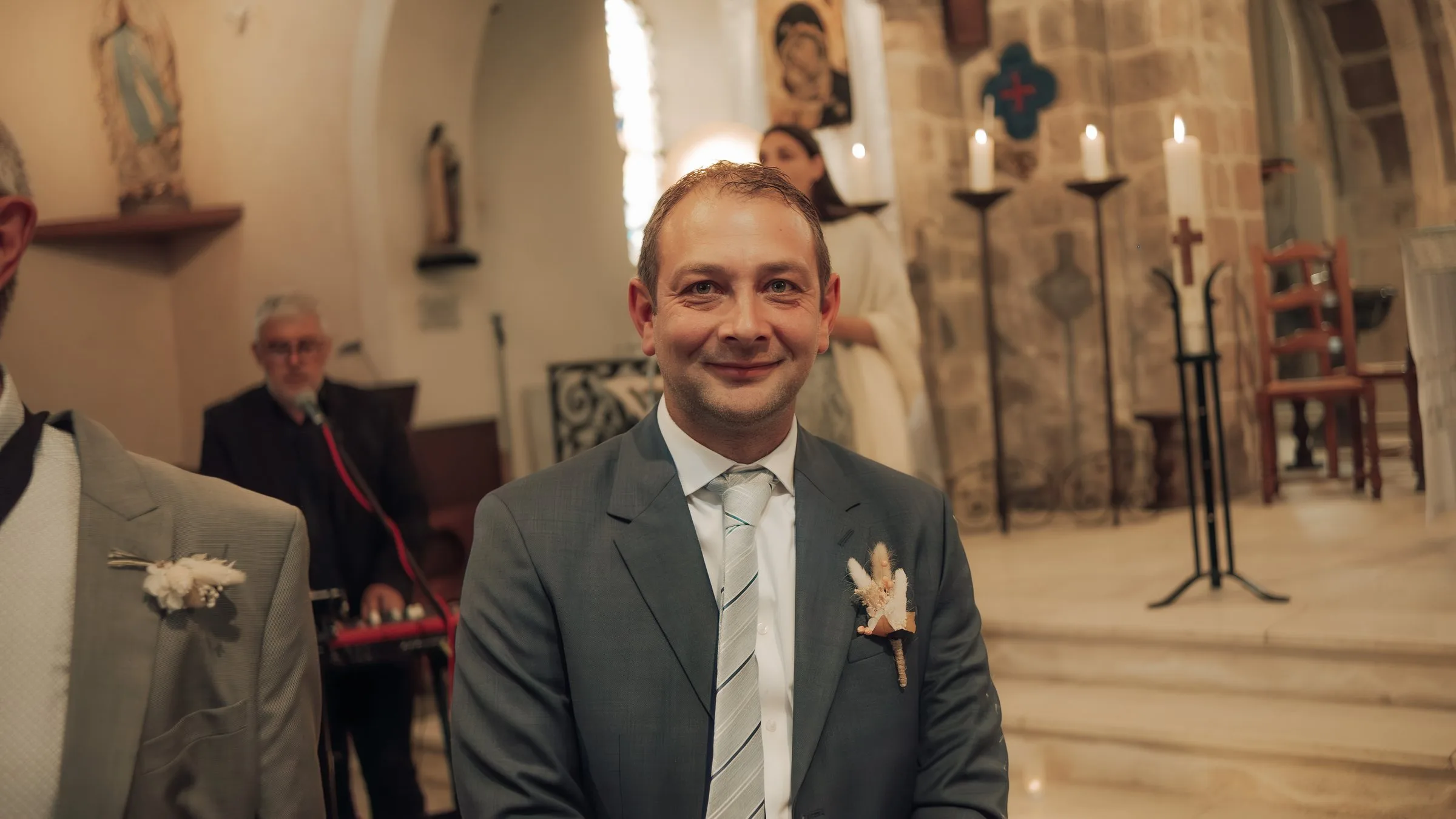 Le marié sourit en attendant la mariée dans l’église