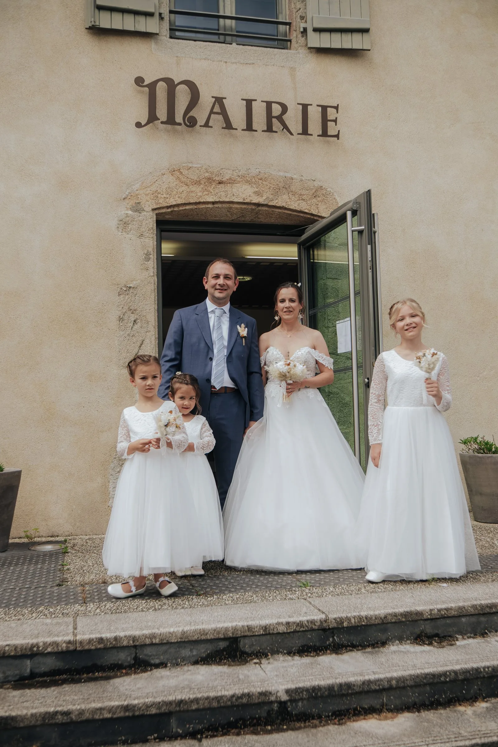 Les mariés et les demoiselles d’honneur sur les marches de la mairie