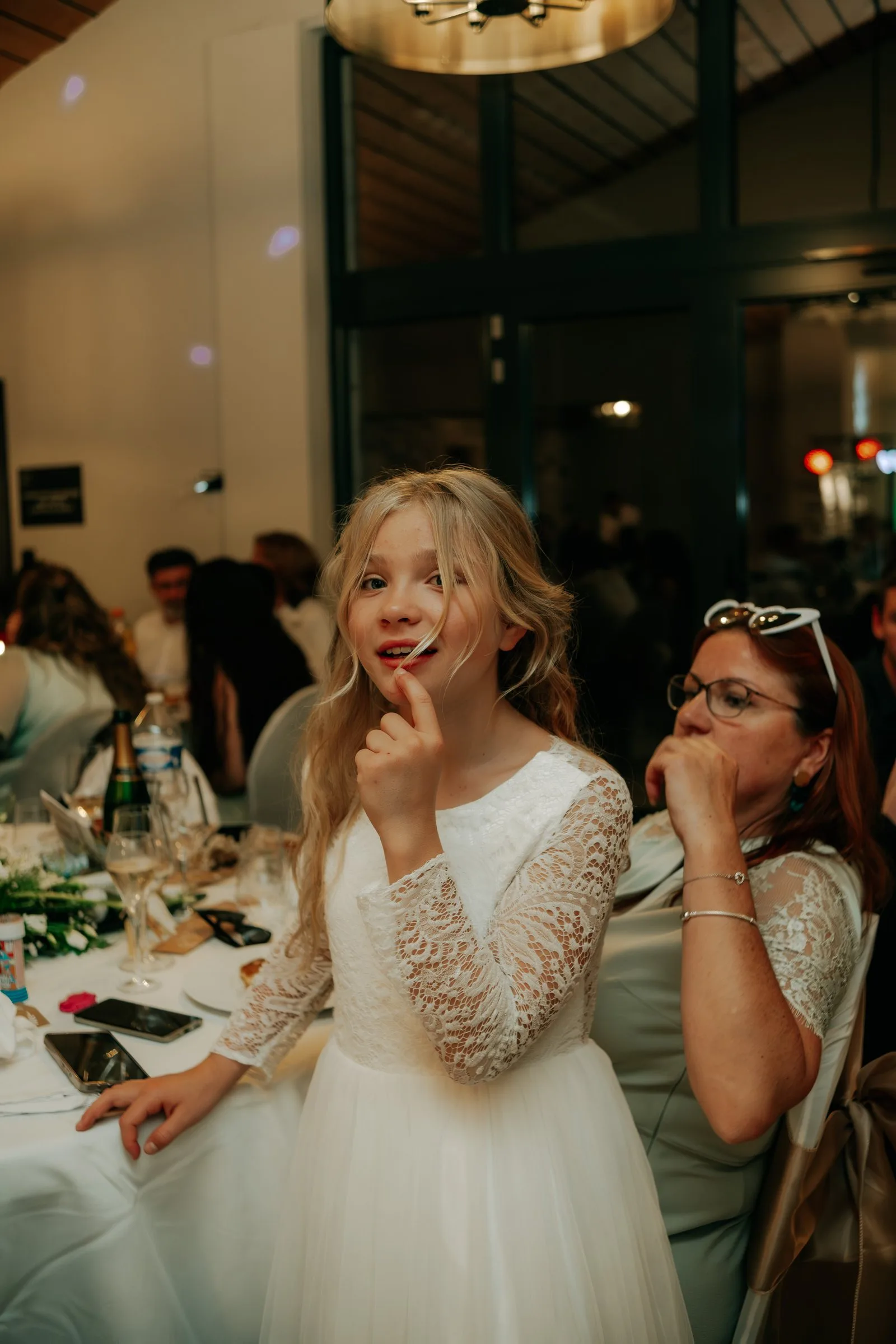 Une petite fille pensive à table pendant la soirée