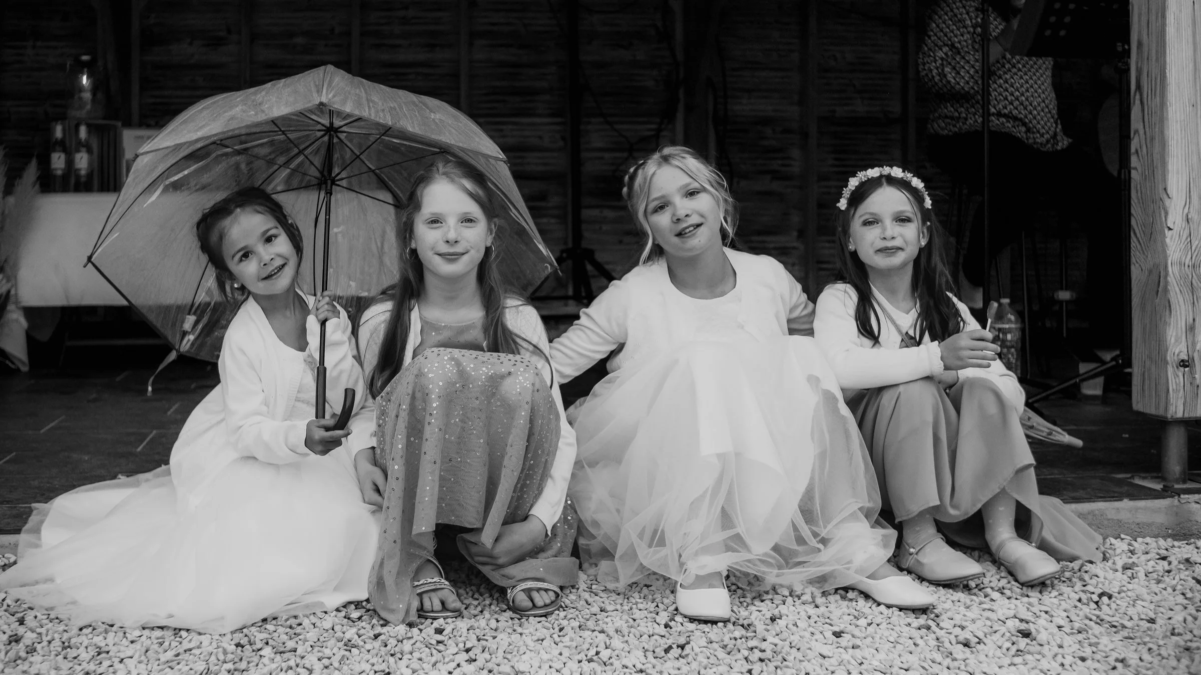 Les petites filles assises sous un parapluie, en noir et blanc