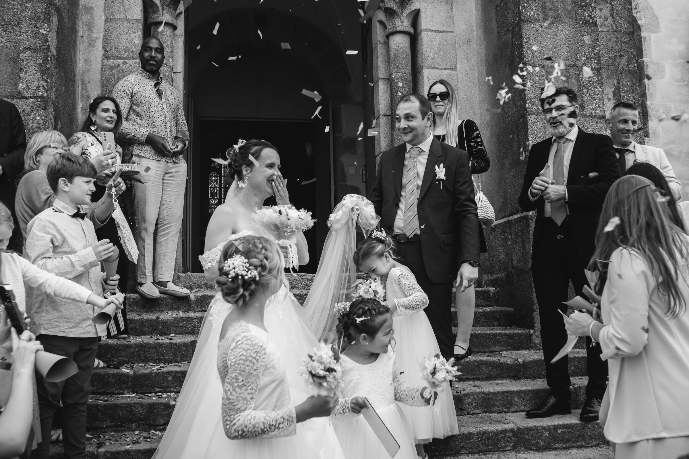 Sortie des mariés sur les marches de l’église, en noir et blanc