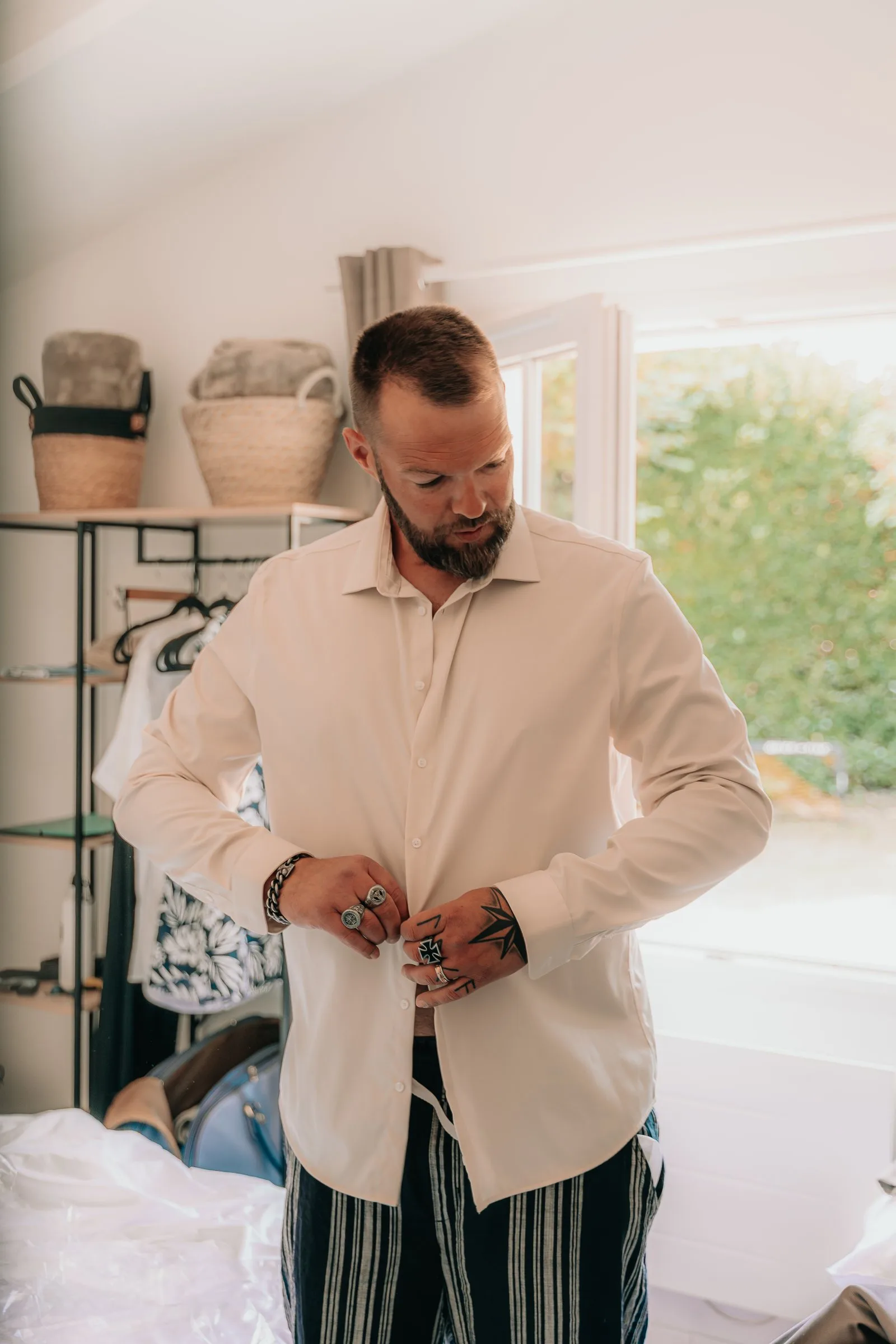 Le marié boutonne sa chemise