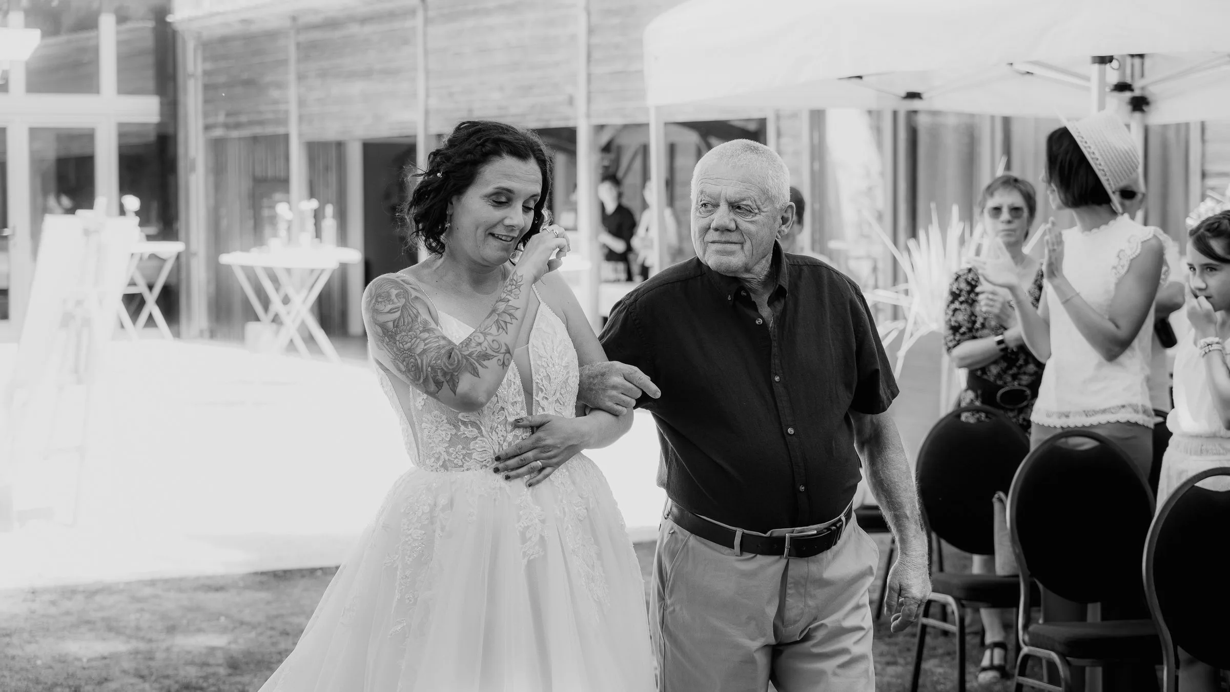 La mariée avance vers la cérémonie, en noir et blanc