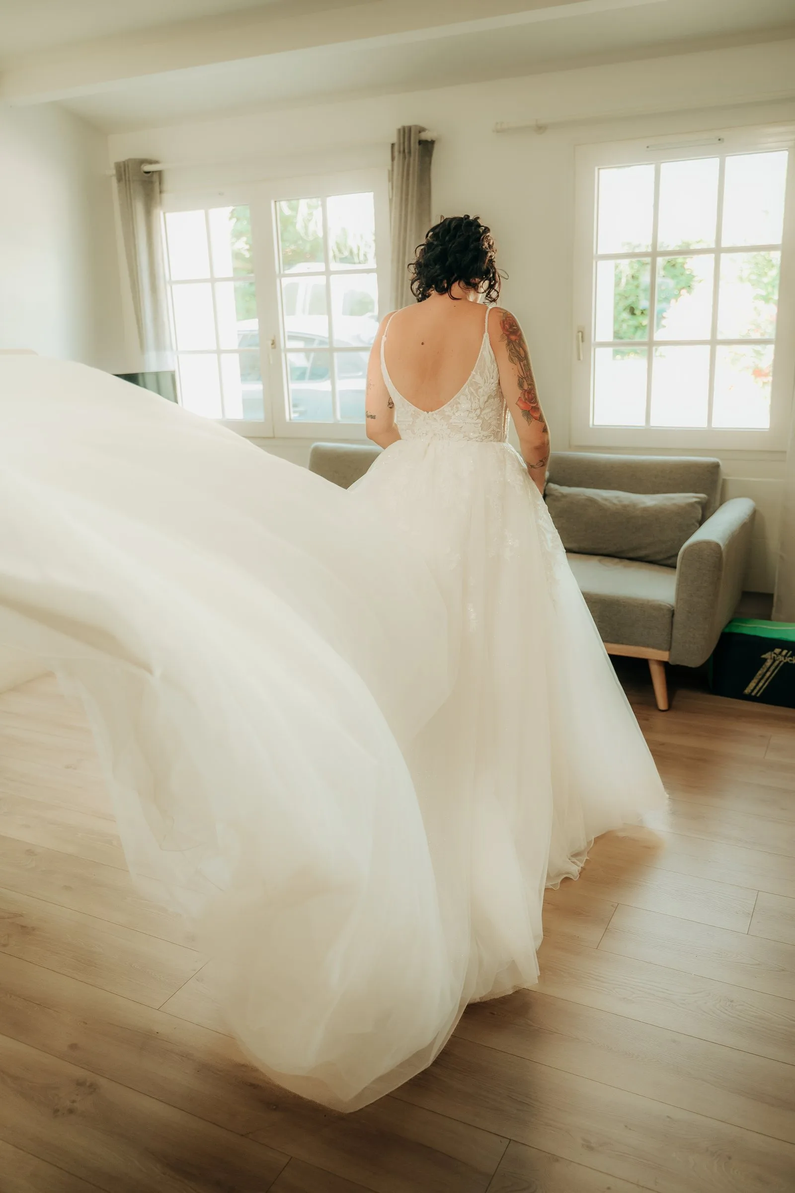 La mariée fait virevolter sa robe dans le salon