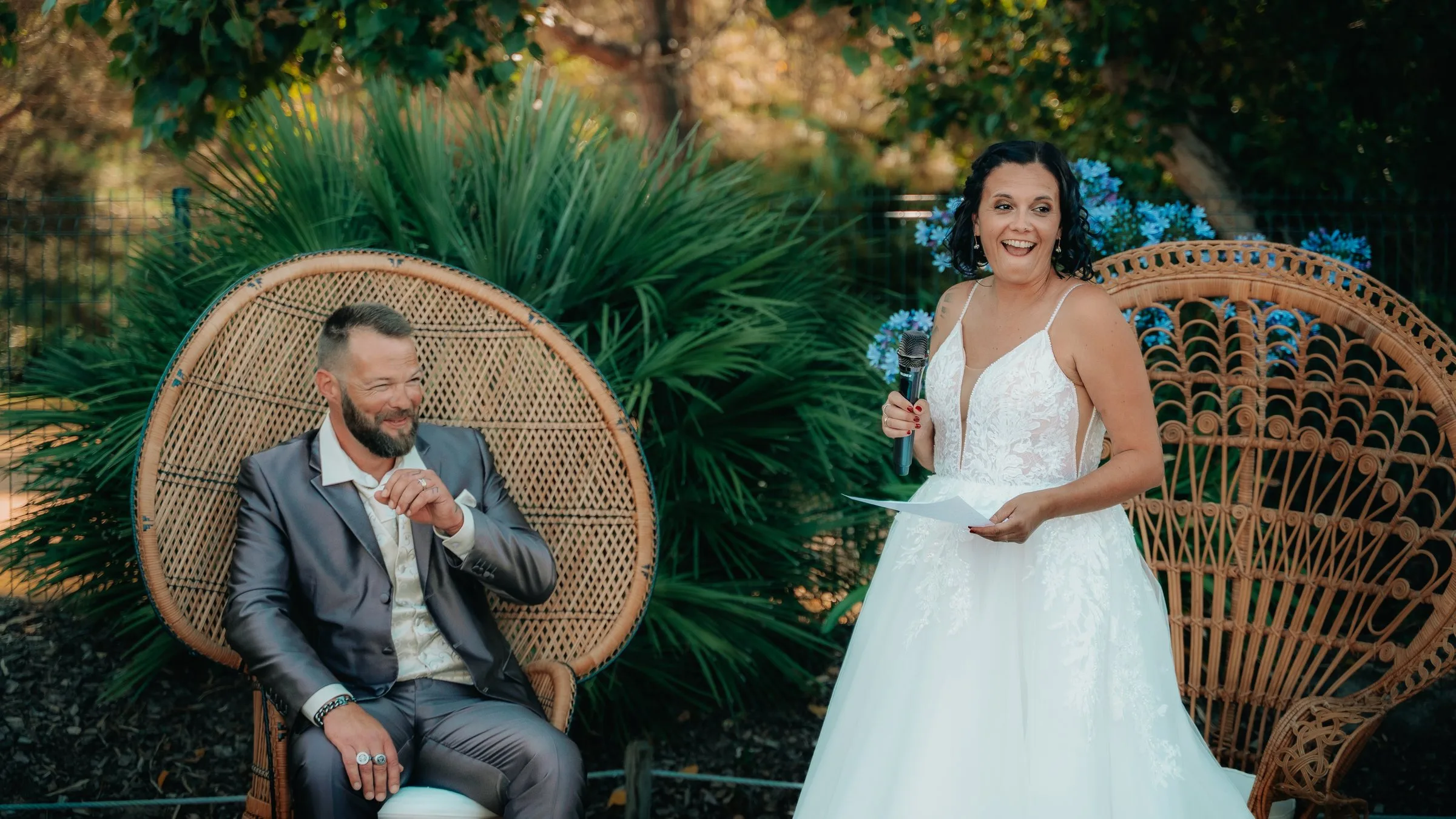 La mariée rit devant les fauteuils en rotin
