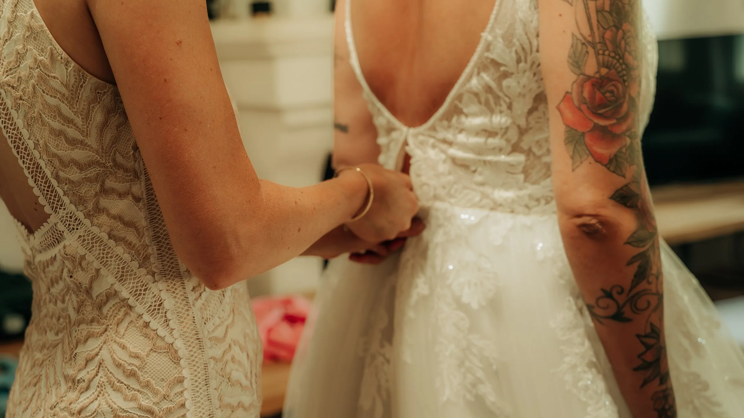 Une proche lace la robe de la mariée