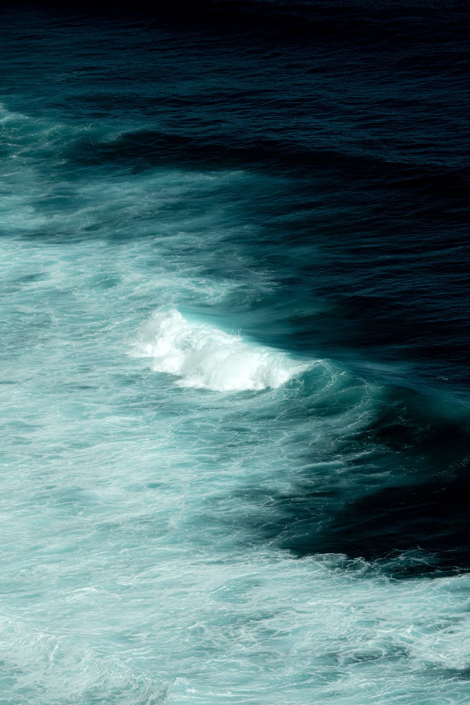 L’écume d’une vague dans une eau turquoise