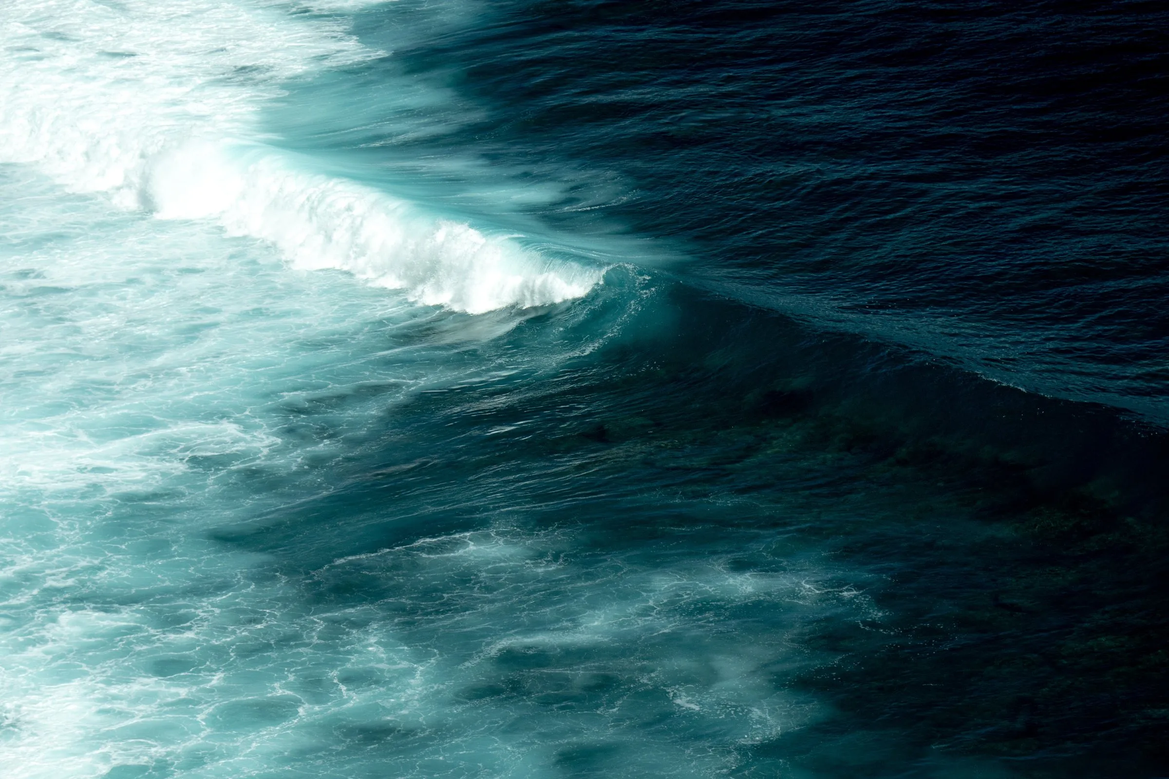 Une vague turquoise se brise dans l’océan Indien