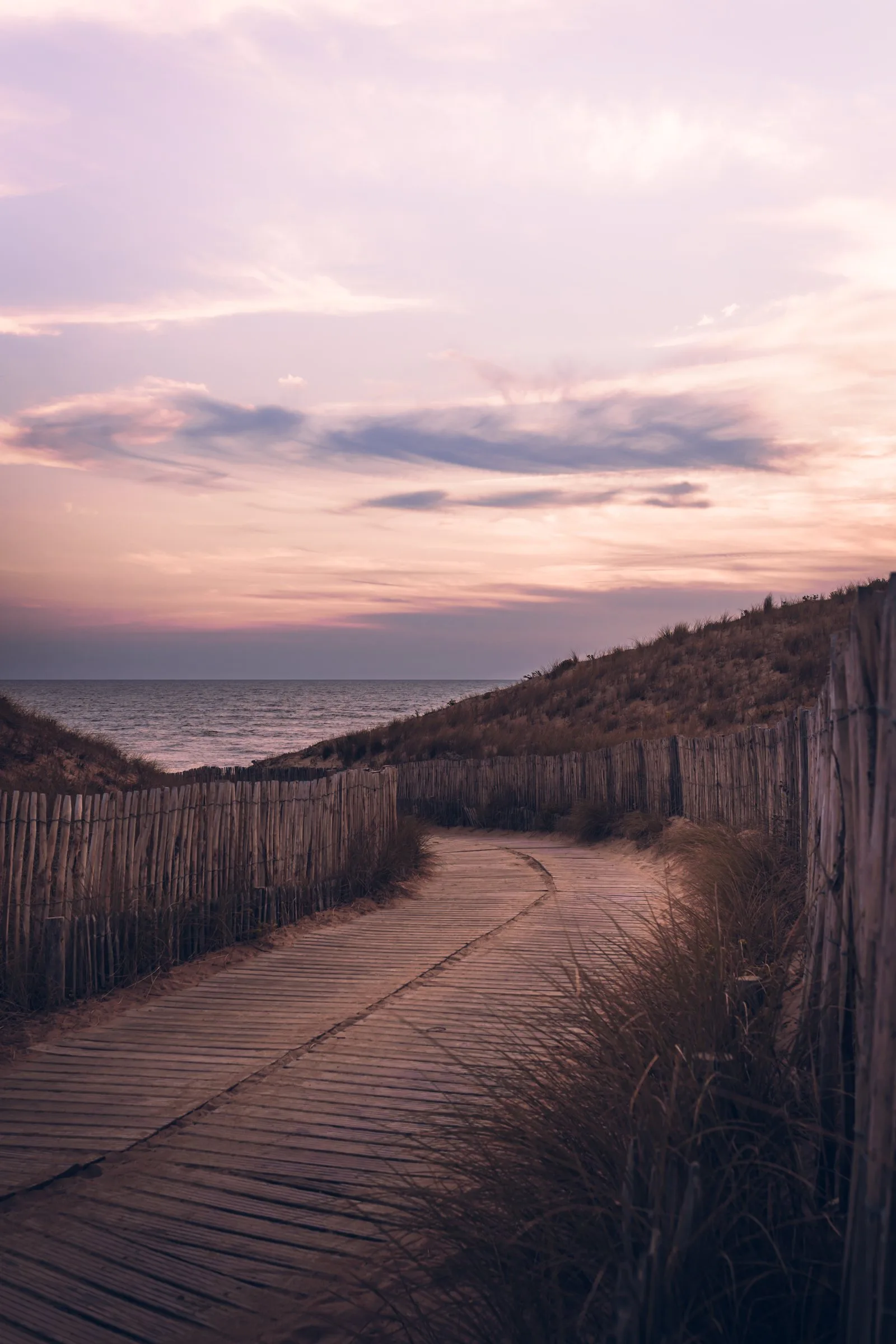 Un chemin en bois entre les dunes, vers la mer