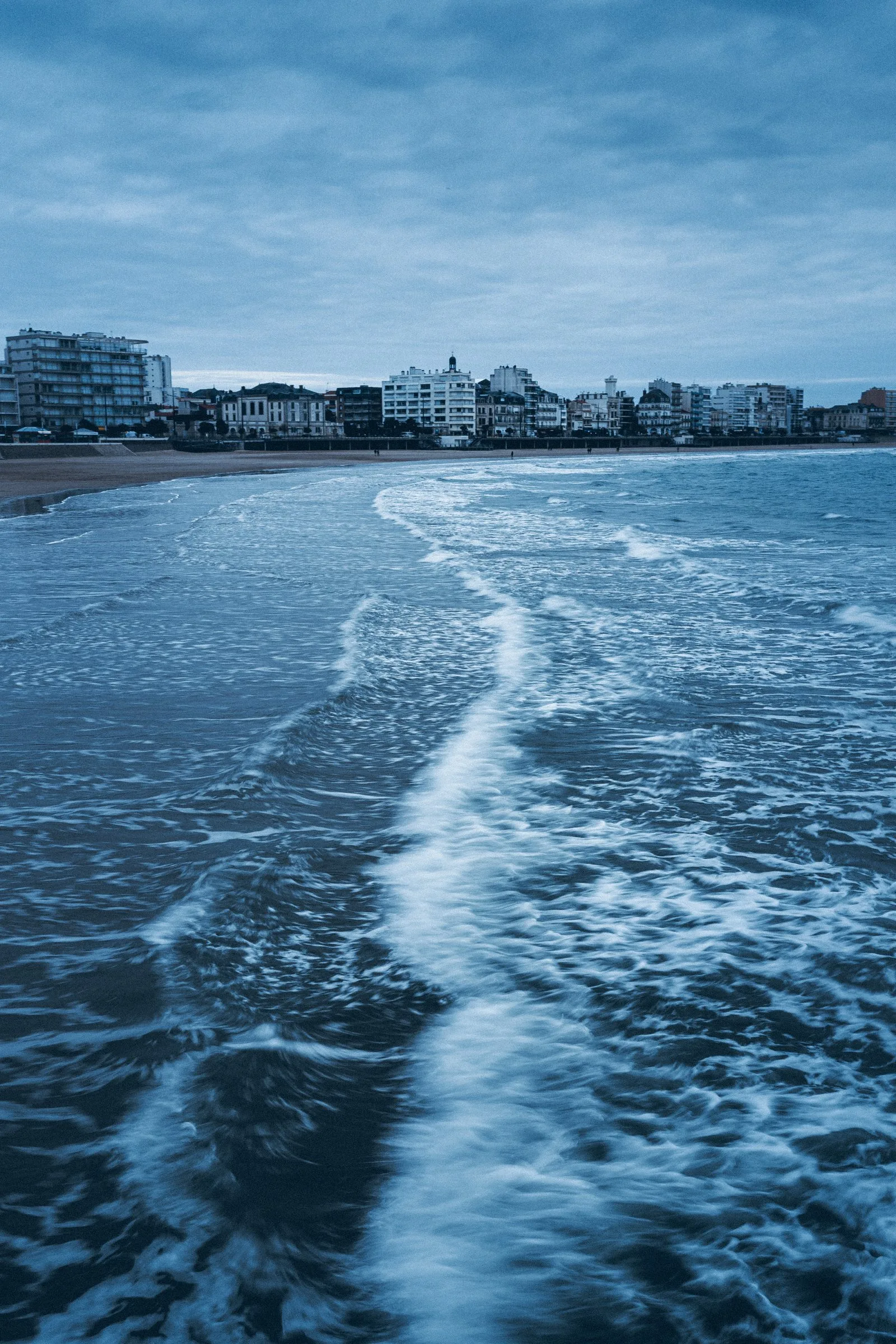 Les vagues sur la grande plage, le remblai au loin