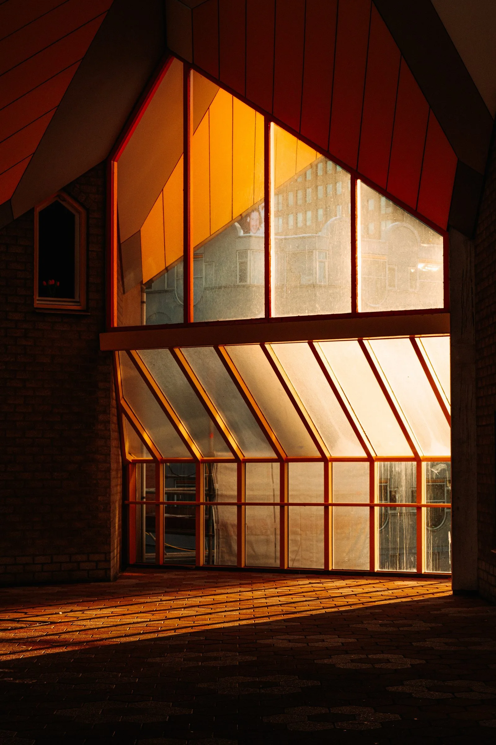 Une façade éclairée par le soleil couchant, sous les maisons cubes