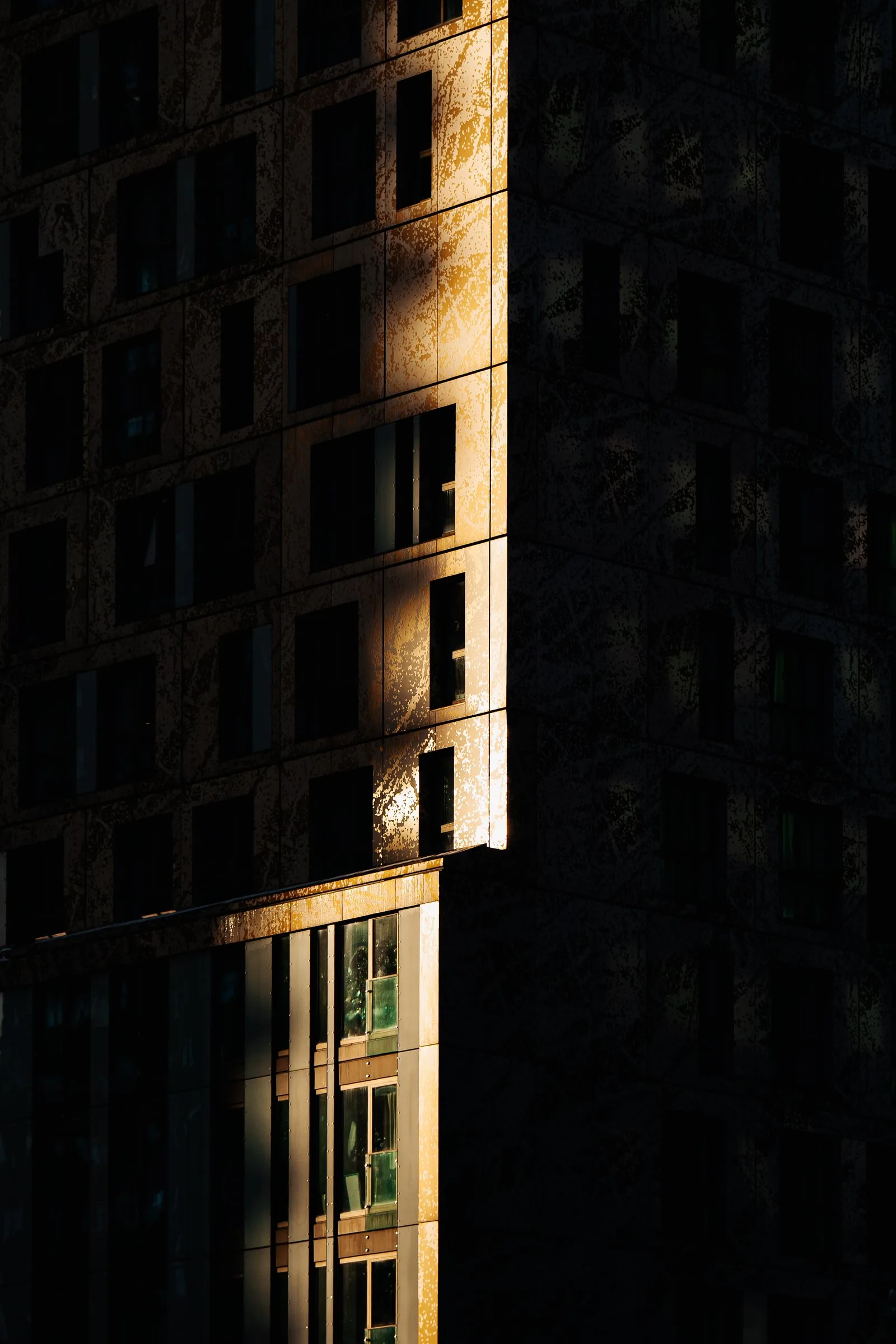 Lumière rasante sur une tour sombre de Rotterdam